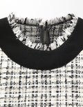 Robe midi en tweed noir et blanc de style fourreau et ligne A par Dolce & Gabbana, détail de la texture et du design.