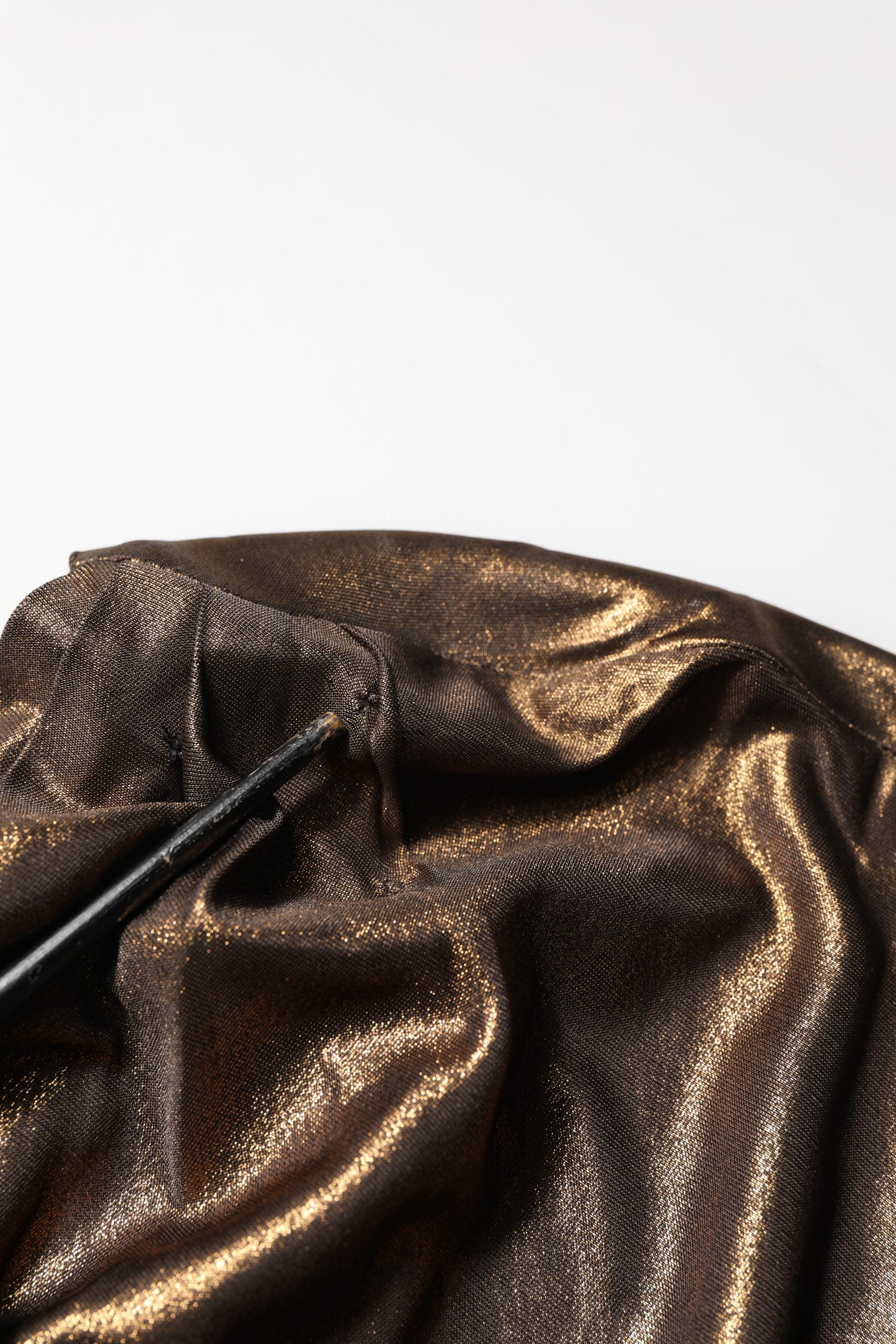 Robe asymétrique bronze Dolce & Gabbana à une épaule avec drapé élégant, vue de face, en tissu fluide et sophistiqué.