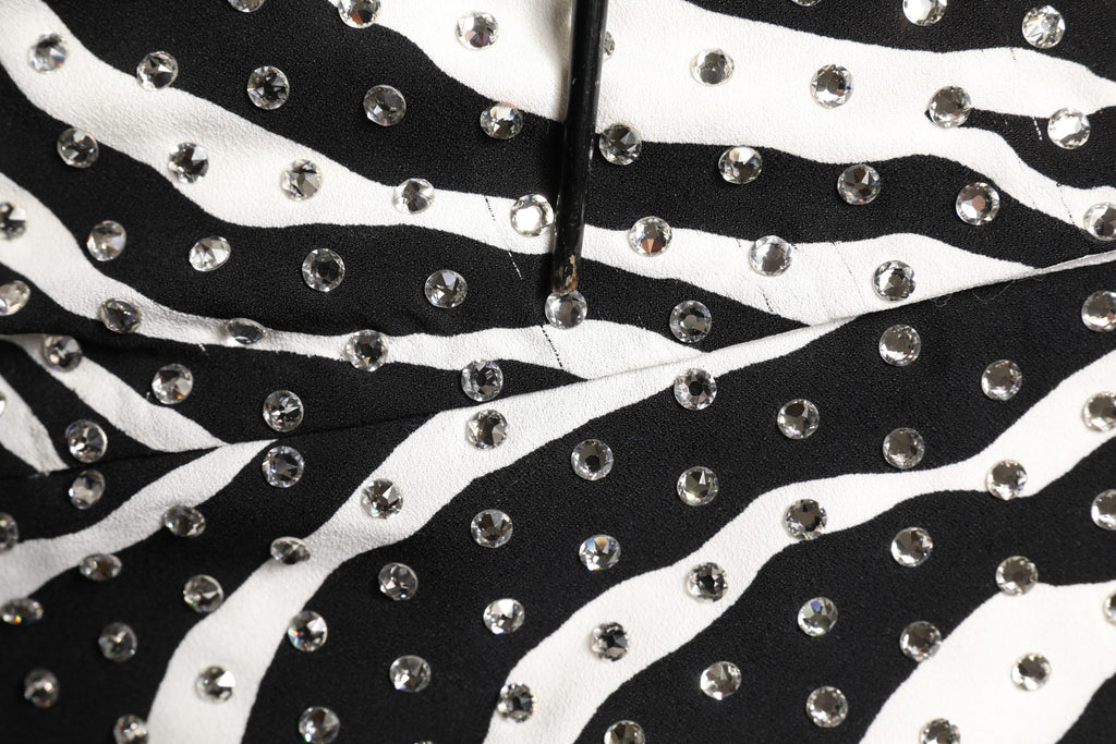 Robe noire et blanche à rayures zèbre de Dolce & Gabbana, ornée de cristaux brillants, pour un look élégant et sophistiqué.