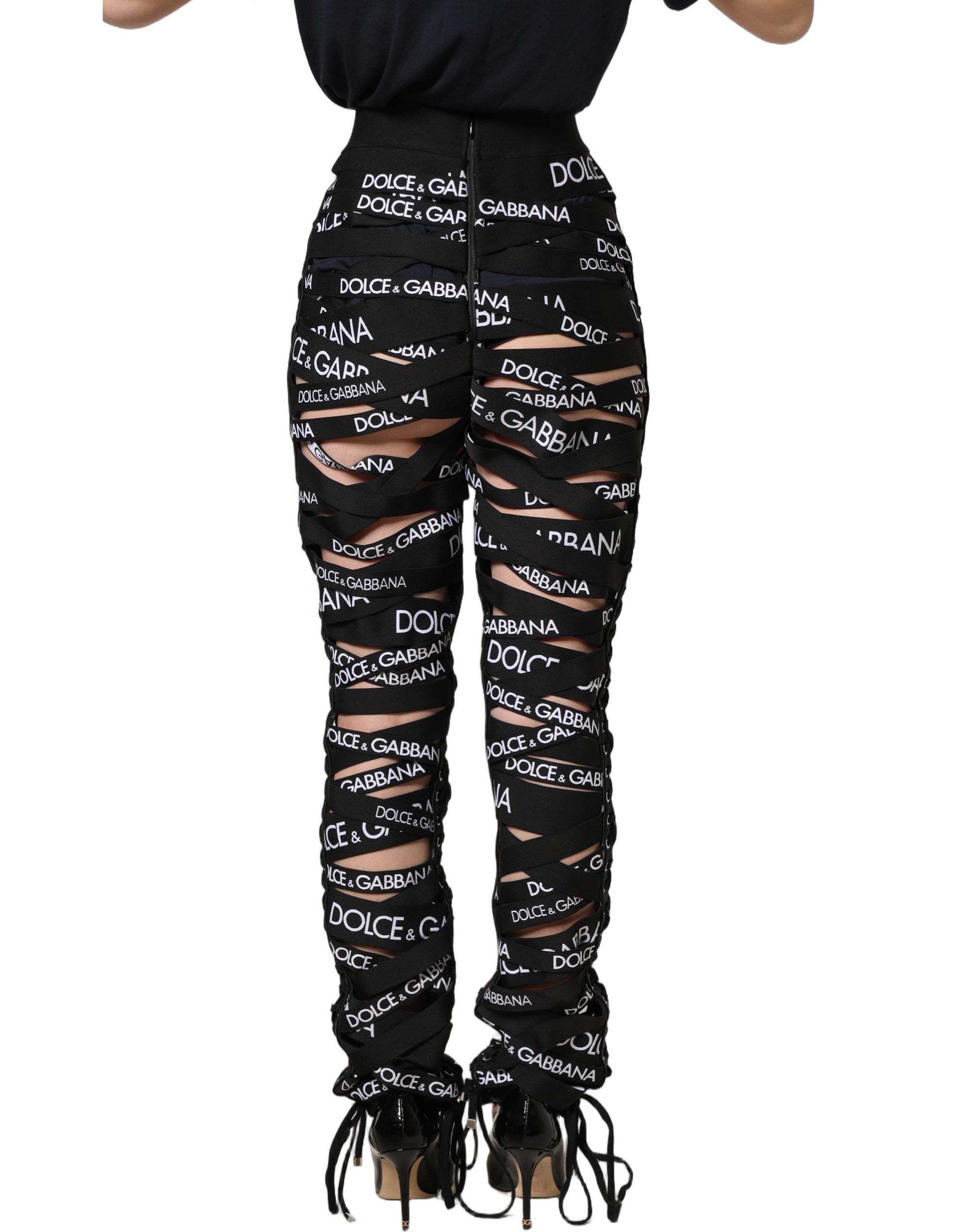 Pantalon skinny taille haute Dolce & Gabbana noir avec bande logo et découpes, style moderne et élégant.