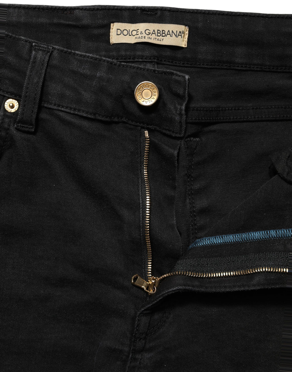 Jeans skinny en denim noir Dolce & Gabbana en coton à taille basse, montrant la coupe ajustée et la texture du tissu.