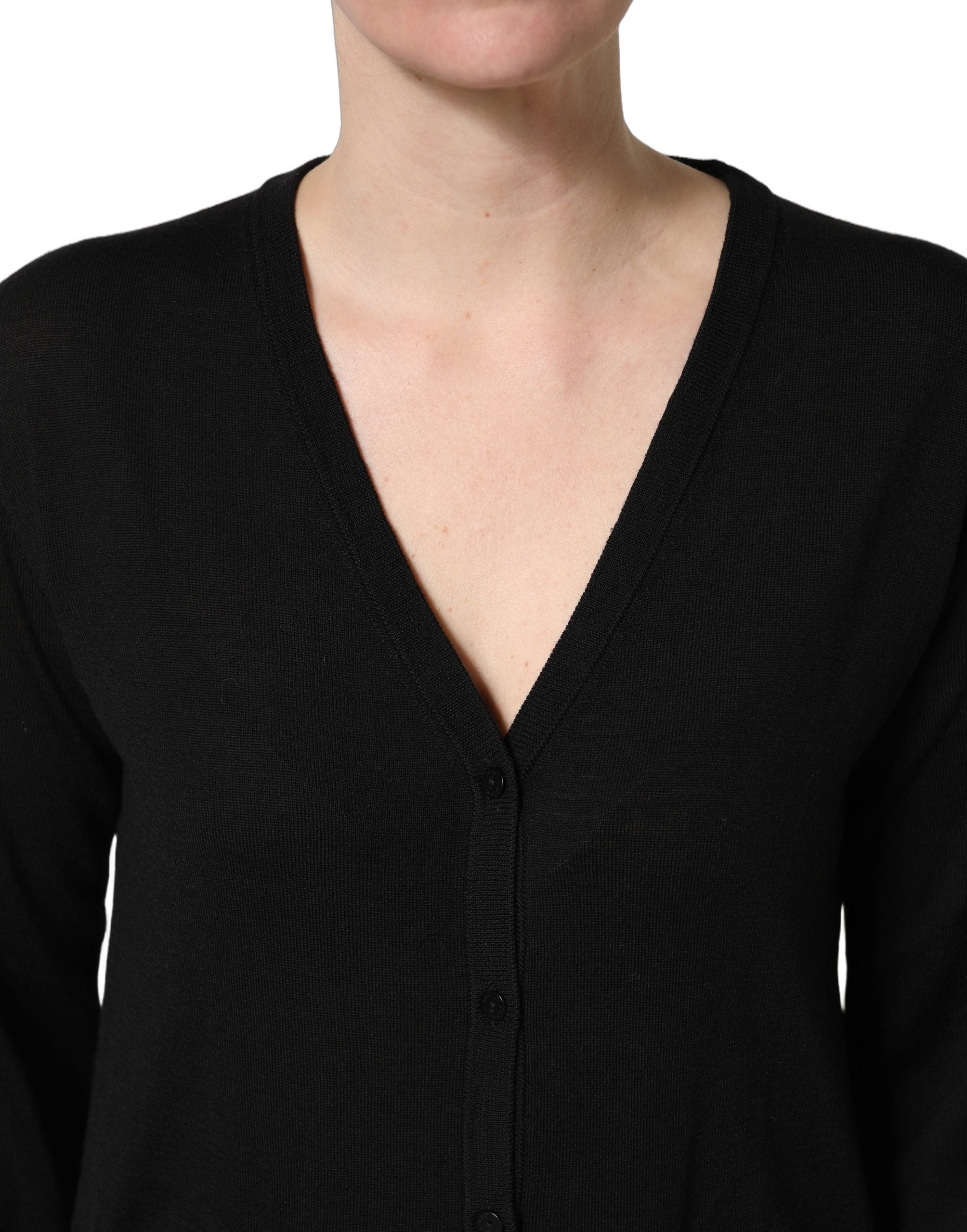 Pull en laine noir Dolce & Gabbana à boutons, cardigan élégant avec col en V et finition côtelée, porté de façon décontractée.