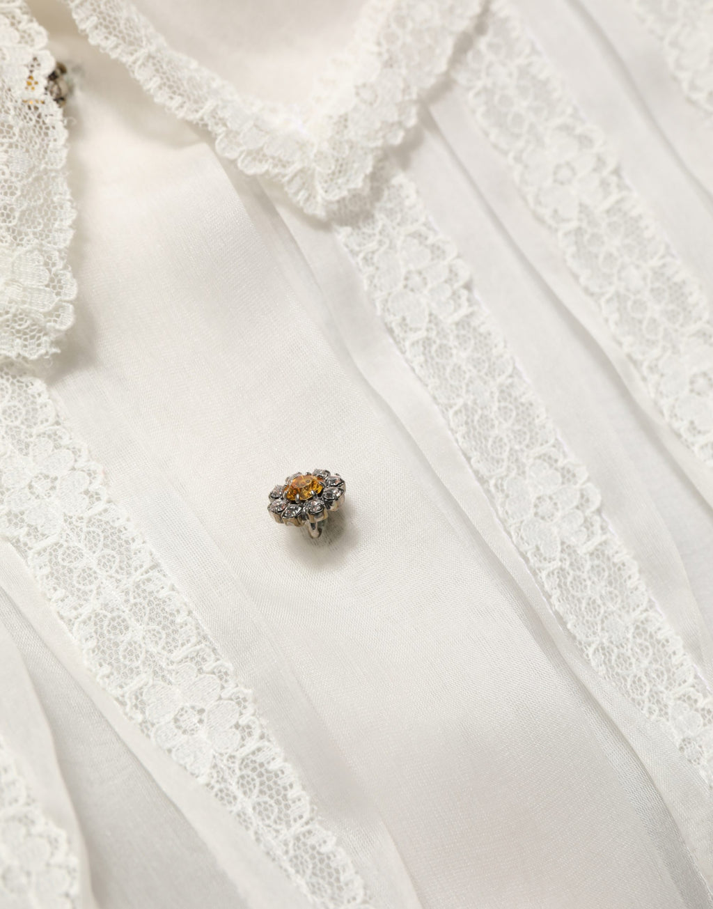 Blouse en soie blanche à volants et boutons de Dolce & Gabbana, transparente, élégante, avec détails féminins.
