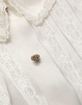 Blouse en soie blanche à volants et boutons de Dolce & Gabbana, transparente, élégante, avec détails féminins.
