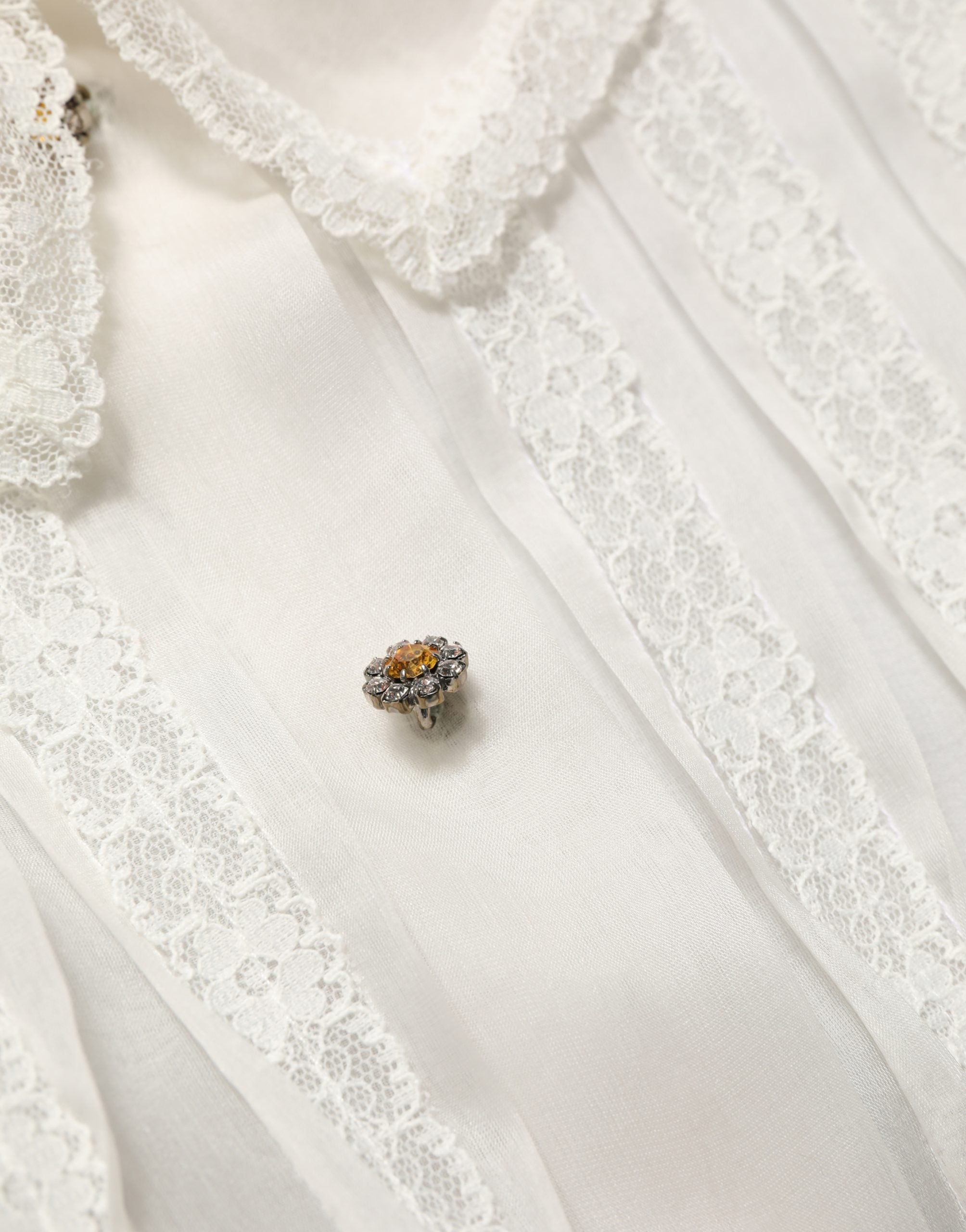 Blouse en soie blanche à volants et boutons de Dolce & Gabbana, transparente, élégante, avec détails féminins.