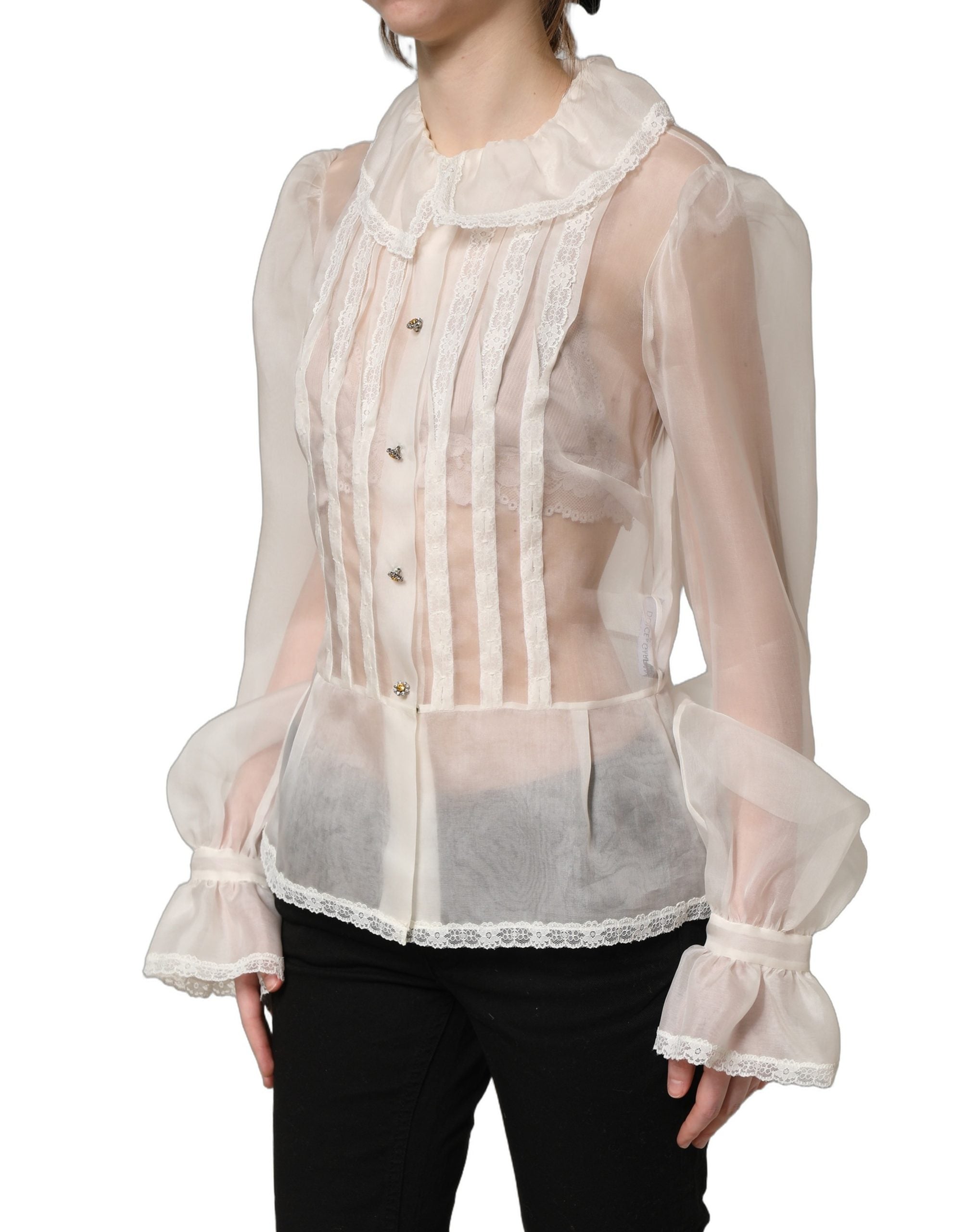 Blouse en soie blanche à volants et boutons de Dolce & Gabbana, tissu léger et transparent, élégance féminine.