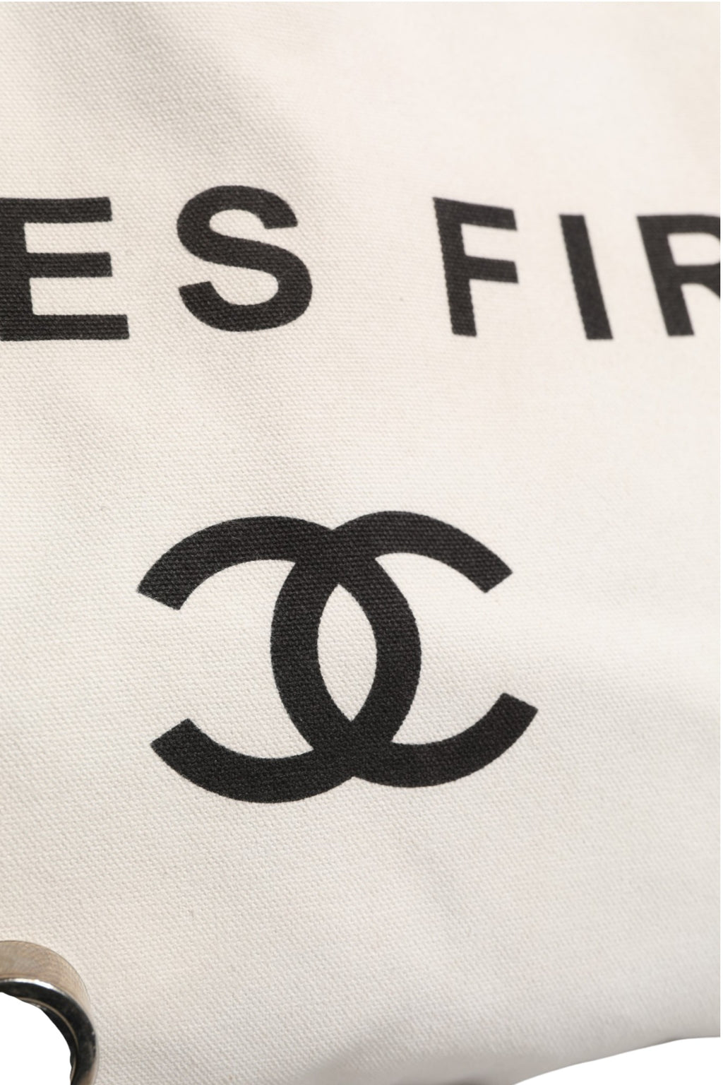 Sac à main Chanel Ladies First en toile blanche et noire, tote élégant pour femmes, avec logo Chanel visible.