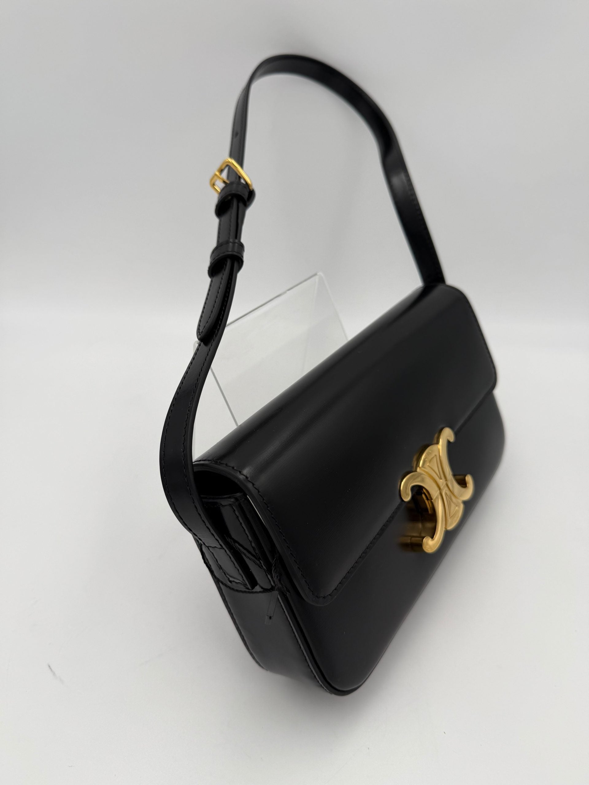 Sac à main Celine Claude Triomphe noir, en cuir, avec boucle or, vue de face avec poignée en cuir.