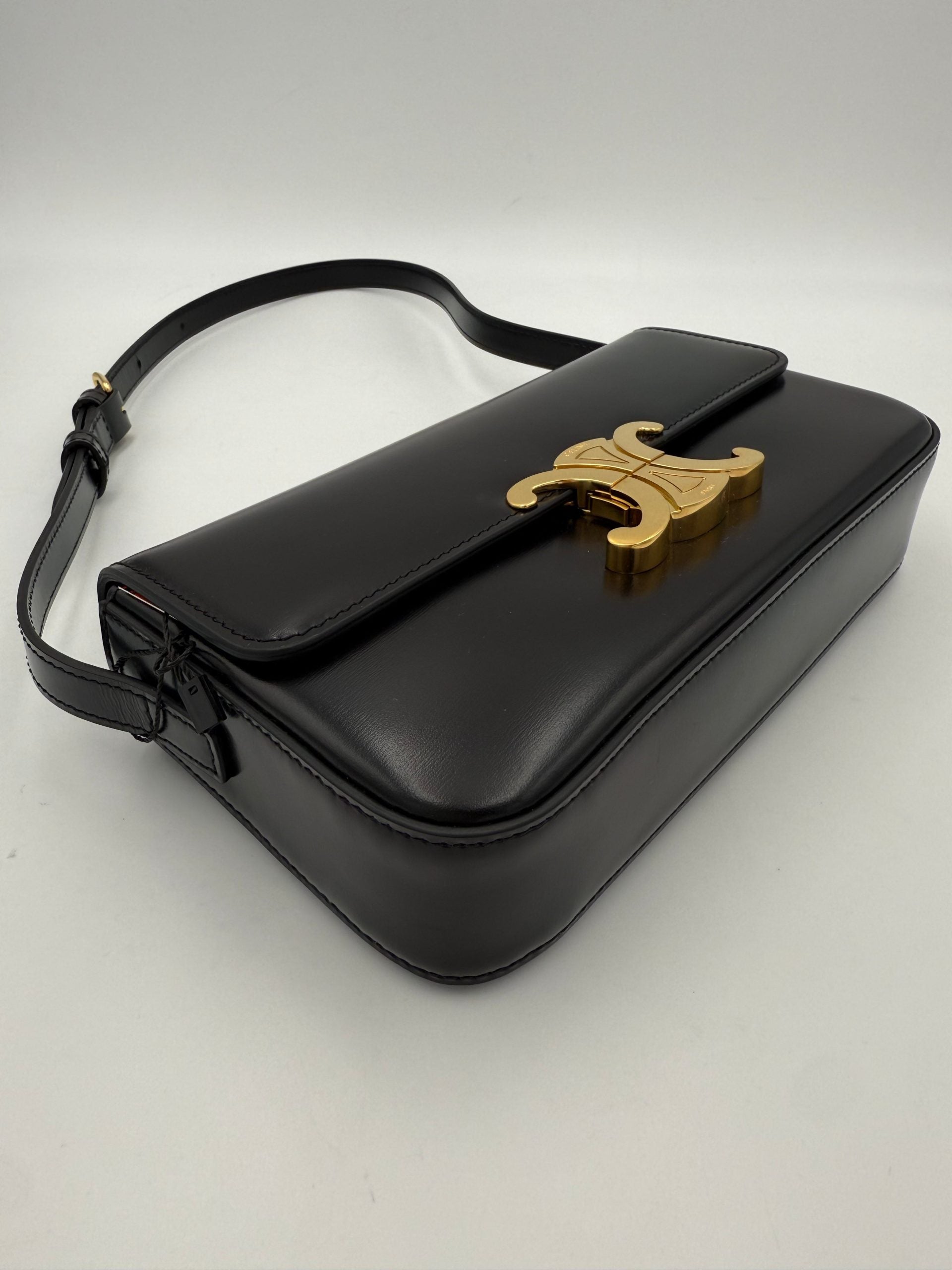 Sac à main Celine Claude Triomphe noir avec bandoulière en cuir et logo emblématique, mode élégante et sophistiquée.