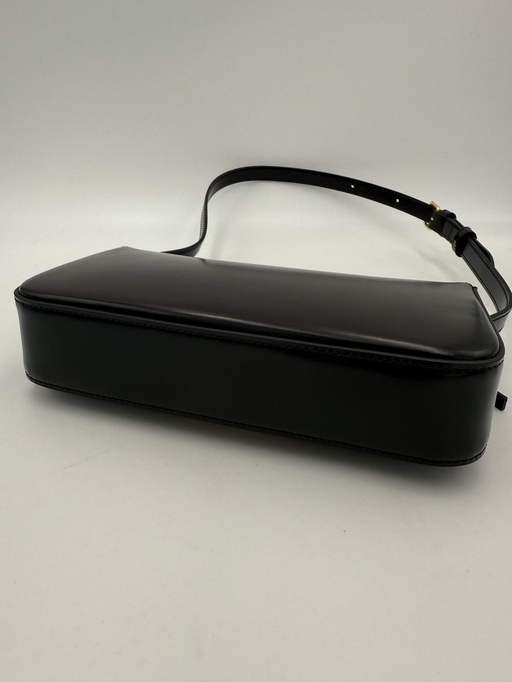 Sac à main noir Celine Claude Triomphe, en cuir, avec logo distinctif et finition élégante, visible dans l'image.