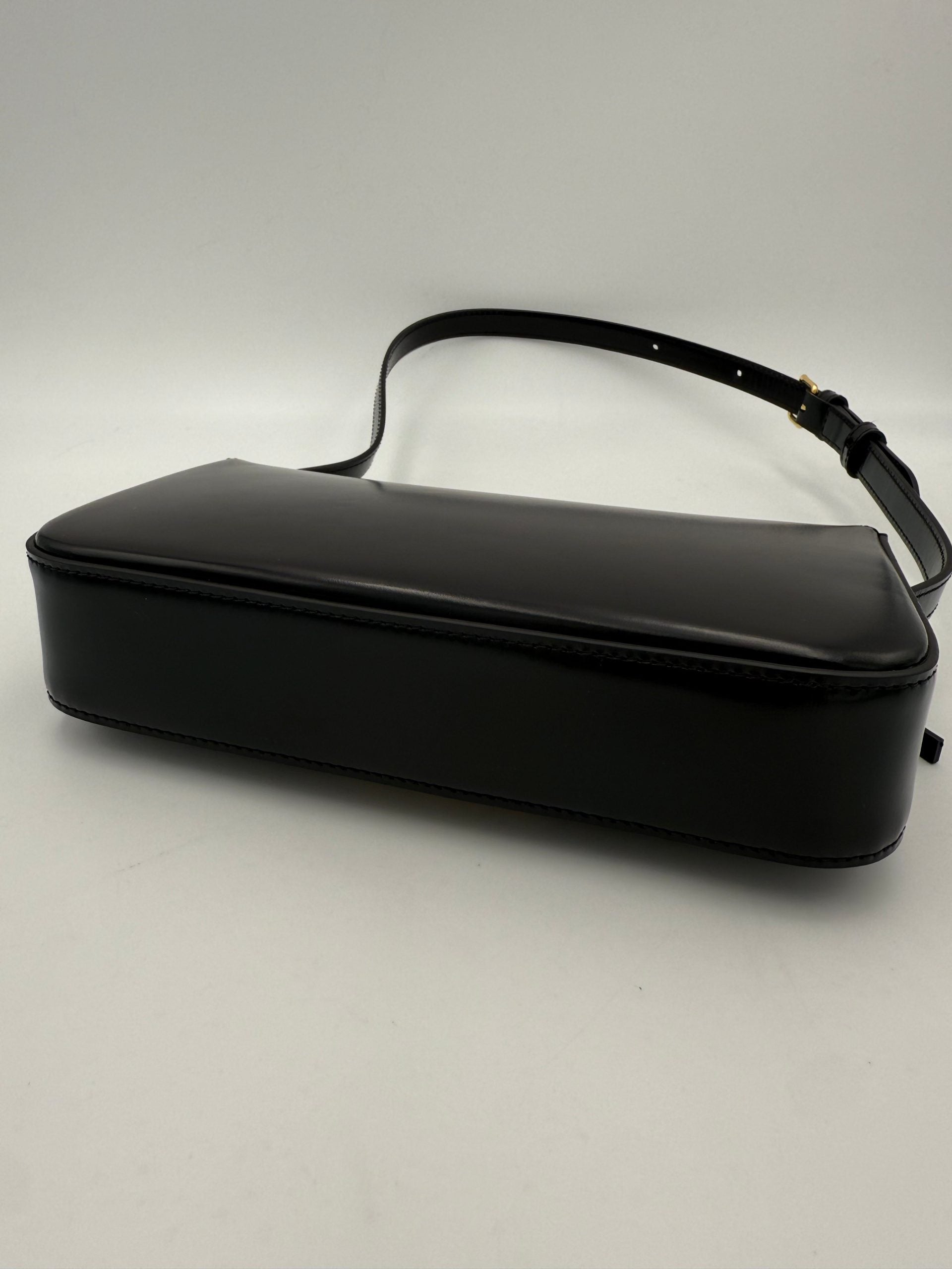 Sac à main noir Celine Claude Triomphe, en cuir, avec logo distinctif et finition élégante, visible dans l'image.