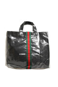 Sac Gucci GG x Comme des Garçons en toile avec logo, grand sac cabas, design distinctif et logo imprimé visible.