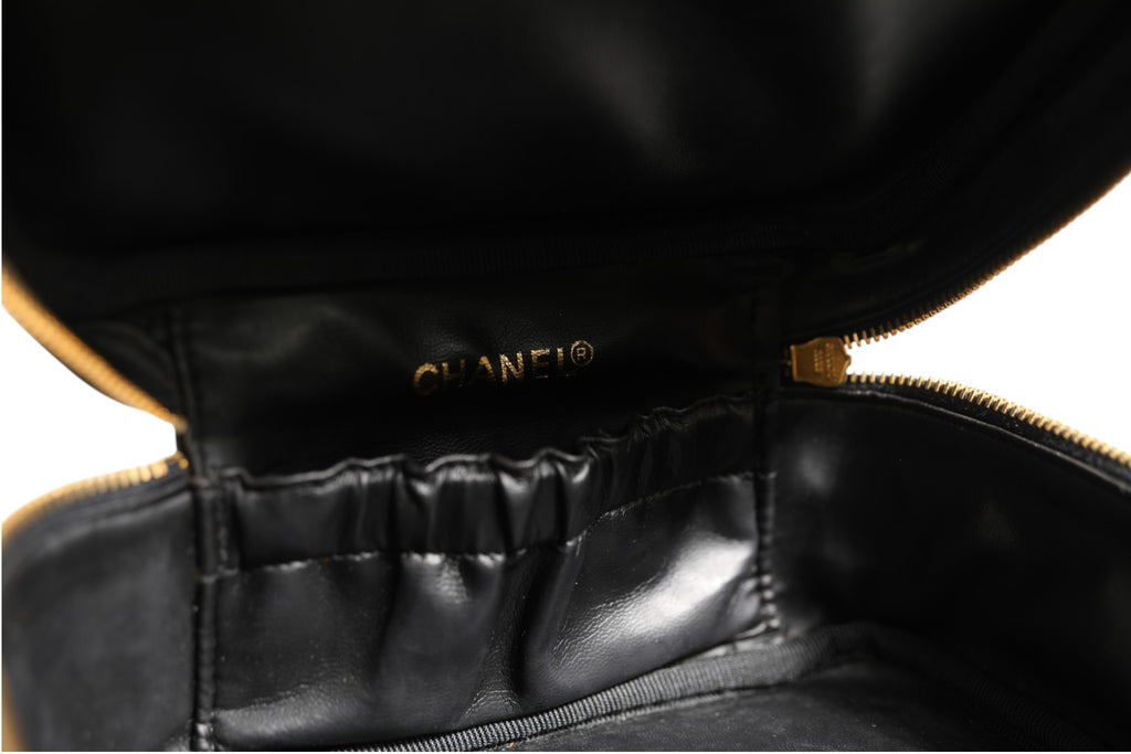 Trousse de maquillage Chanel noire et or avec logo Chanel, élégante et sophistiquée, vue de face.