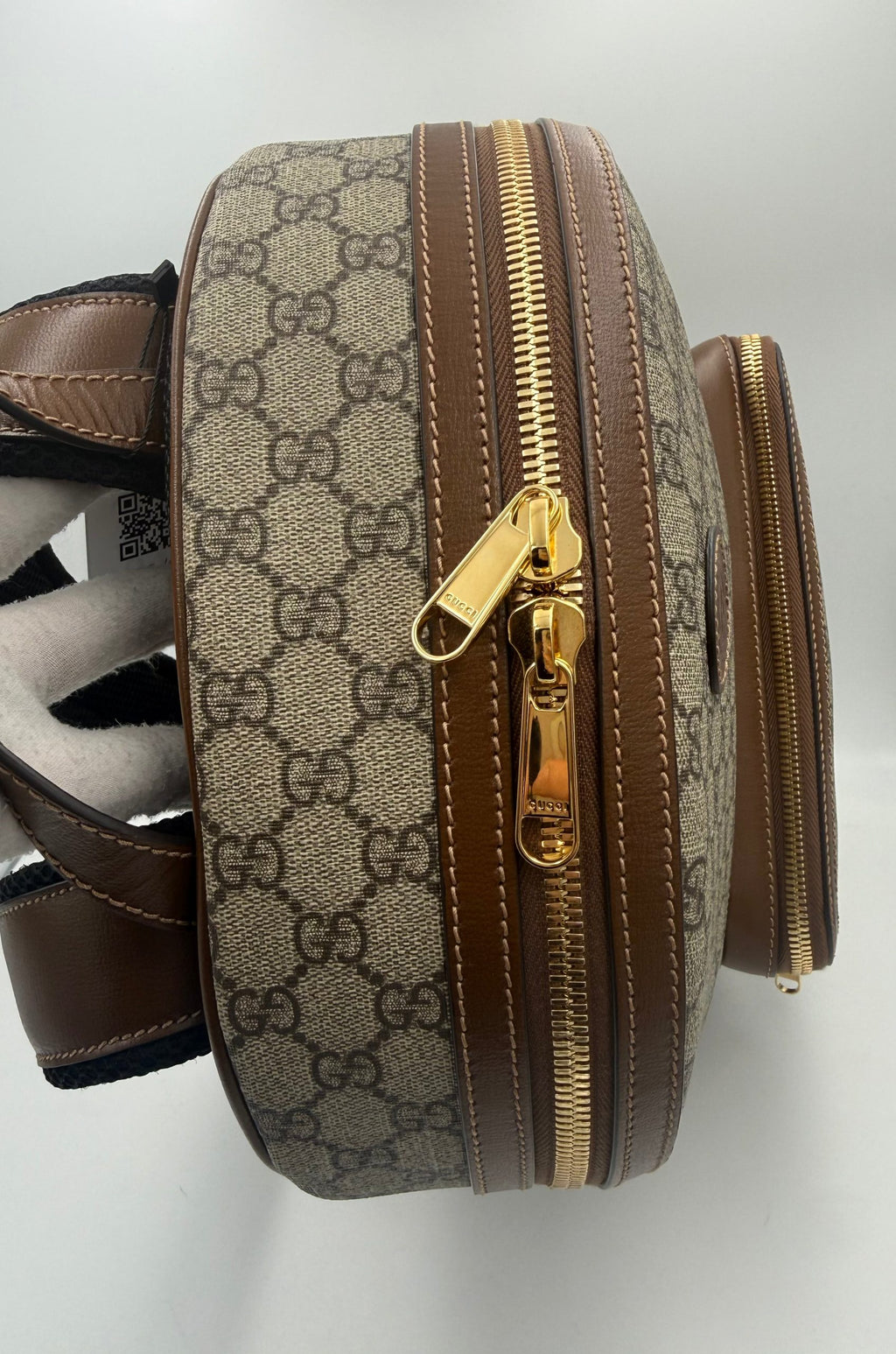 Sac à dos Gucci GG Supreme et cuir, avec logo emblématique et détails en cuir, pour un style élégant et pratique.