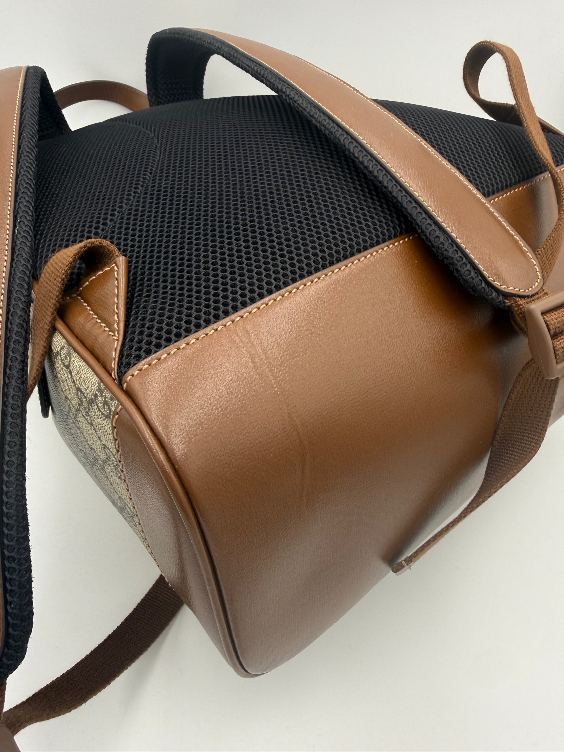 Sac à dos Gucci GG Supreme et cuir, élégant et durable, avec logo emblématique et détails en cuir noir.