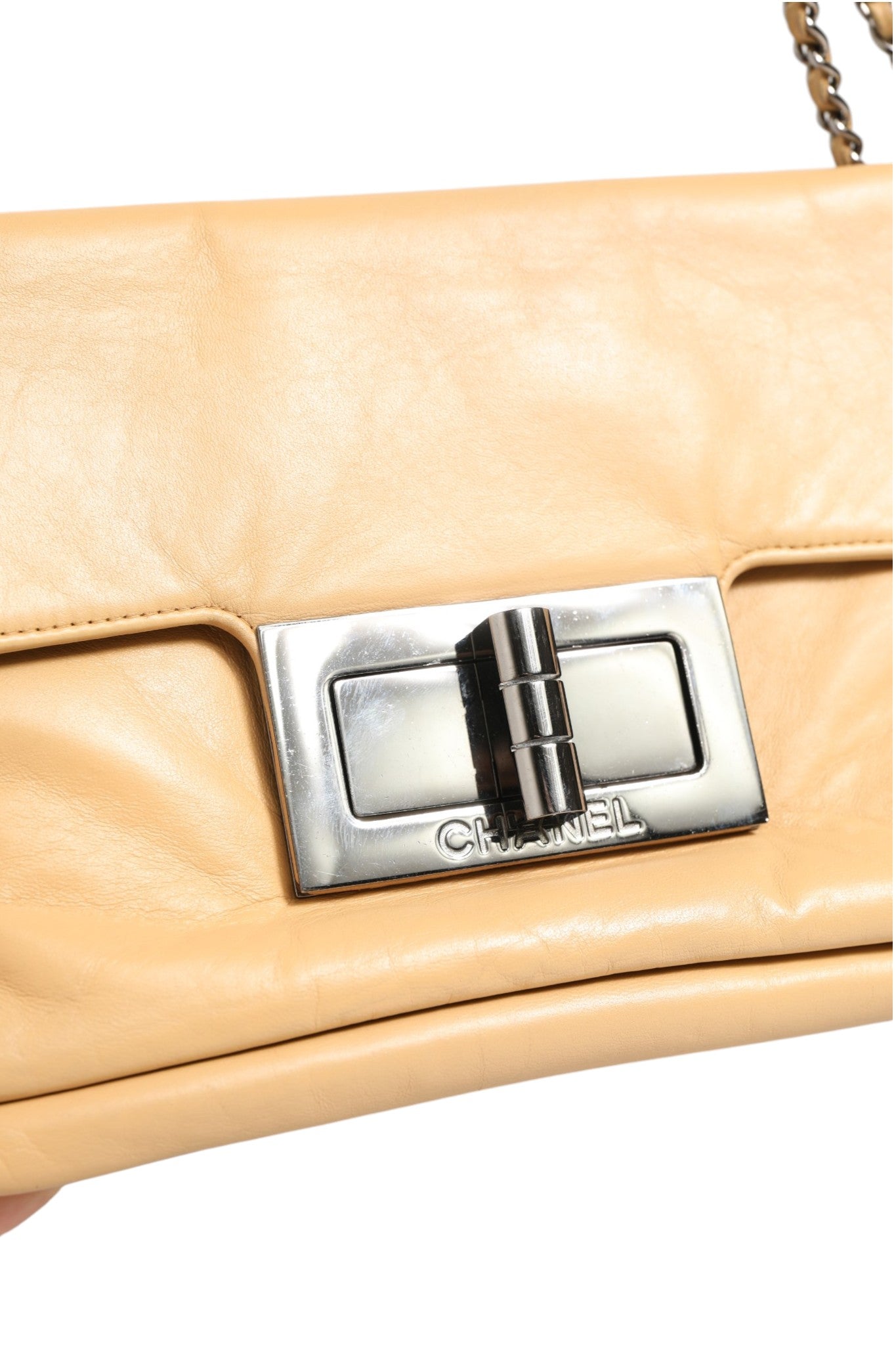 Sac à main Chanel beige en cuir d'agneau avec verrou Mademoiselle géant et rabat, finition élégante et design classique.