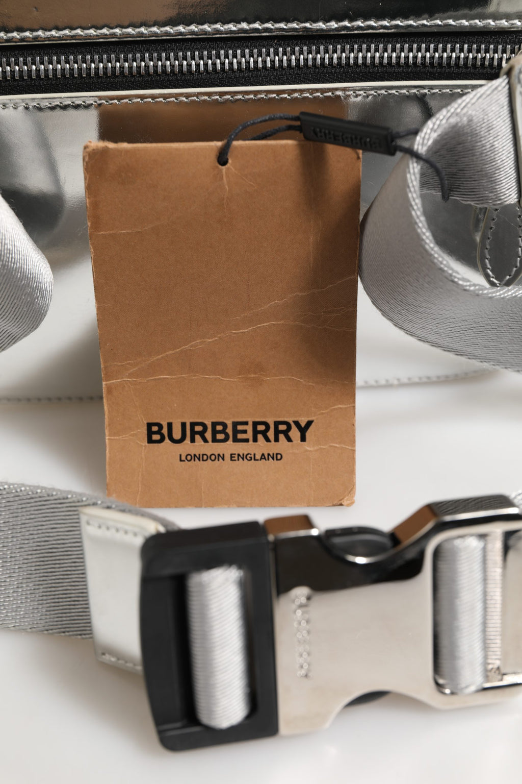 Sac banane Burberry en synthétique argenté, style moderne, avec boucle et logo visible sur le devant.