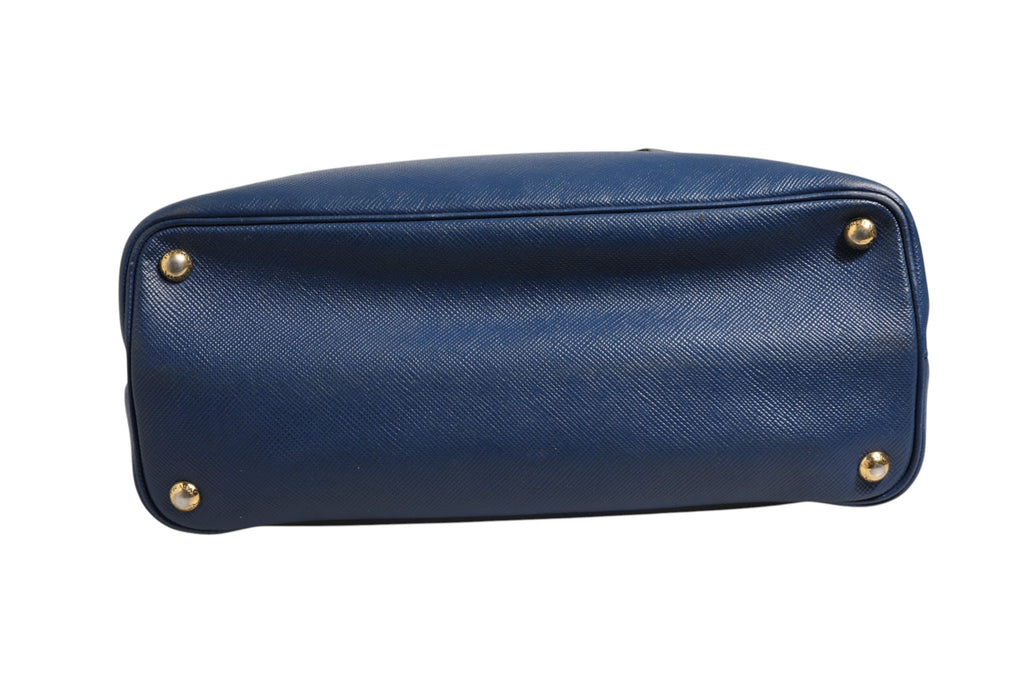 Sac Prada en cuir saffiano bleu, sac à main 2 voies avec bandoulière et poignées, style élégant et sophistiqué.