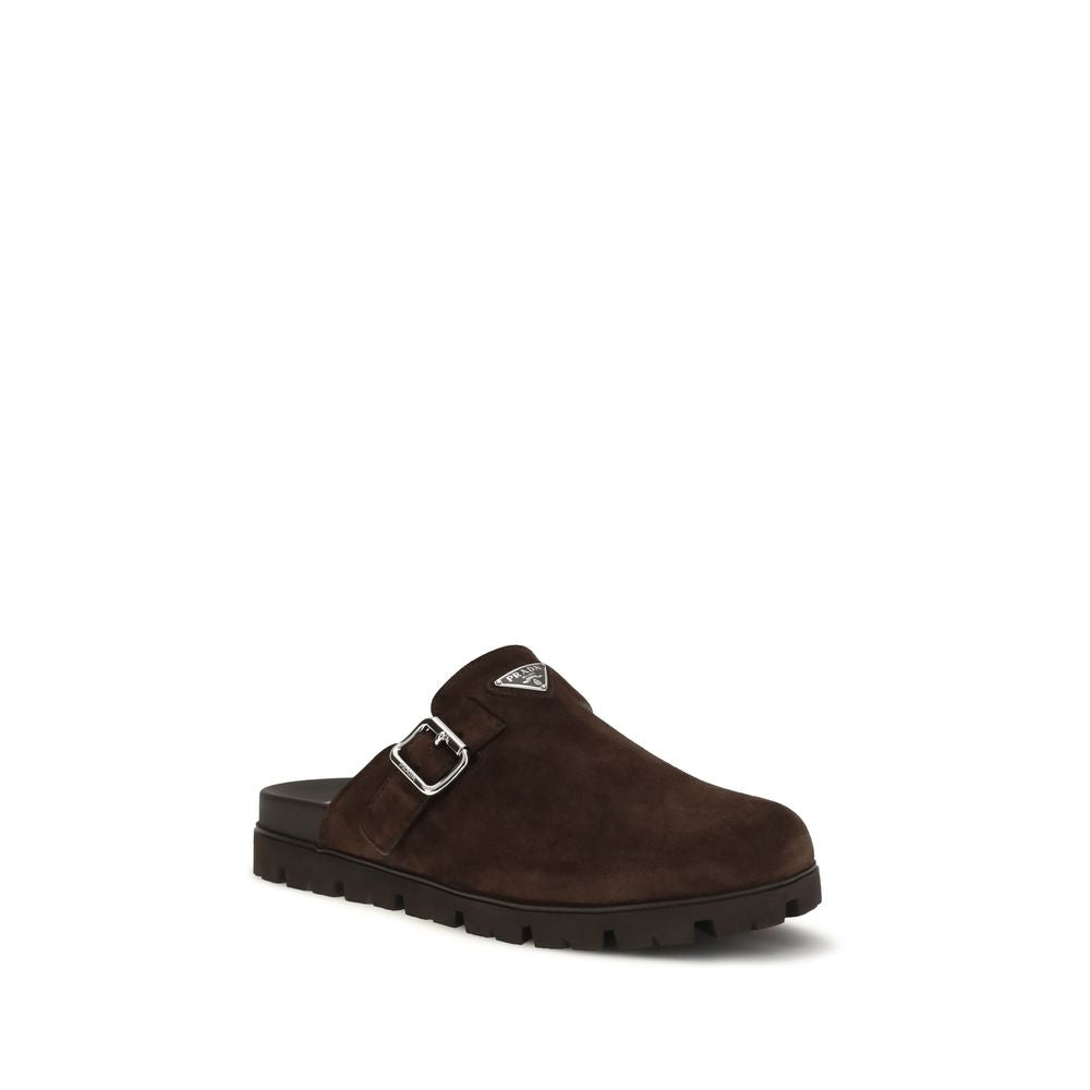 Mules en cuir de veau marron Prada Bos Taurus avec semelle en cuir, visibles sur fond neutre.