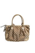 Sac Gucci Sukey en toile 2 voies, avec poignées en cuir et logo Gucci, placé sur un fond neutre.