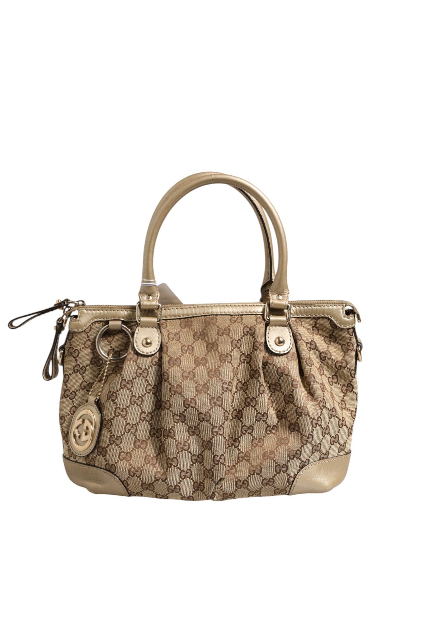 Sac Gucci Sukey en toile 2 voies, avec poignées en cuir et logo Gucci, placé sur un fond neutre.
