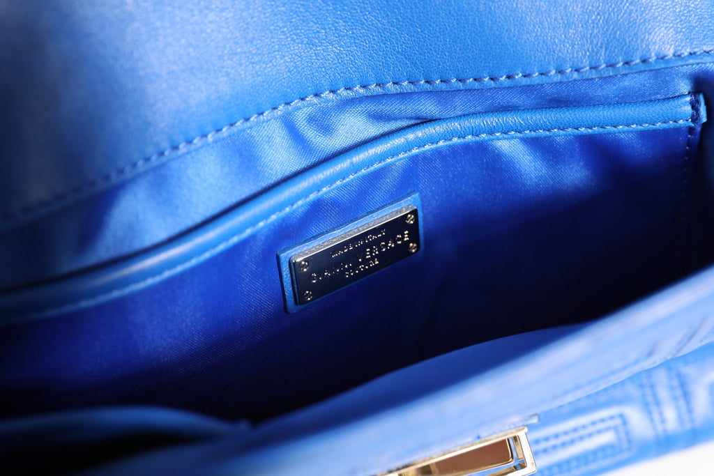 Sac à main en cuir matelassé Versace Couture, sac à épaule élégant avec logo Versace visible sur le devant.