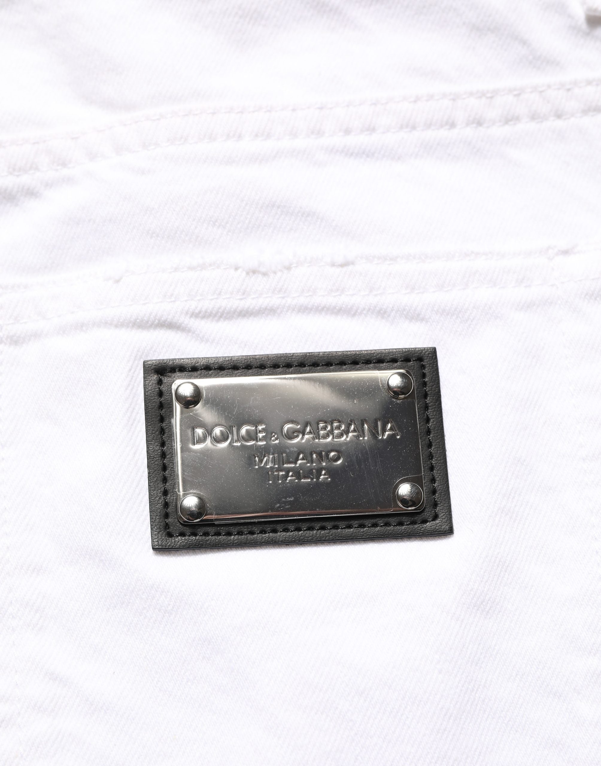 Jeans homme Dolce & Gabbana en coton blanc déchiré, coupe slim ajustée, denim tendance visible sur l’image.