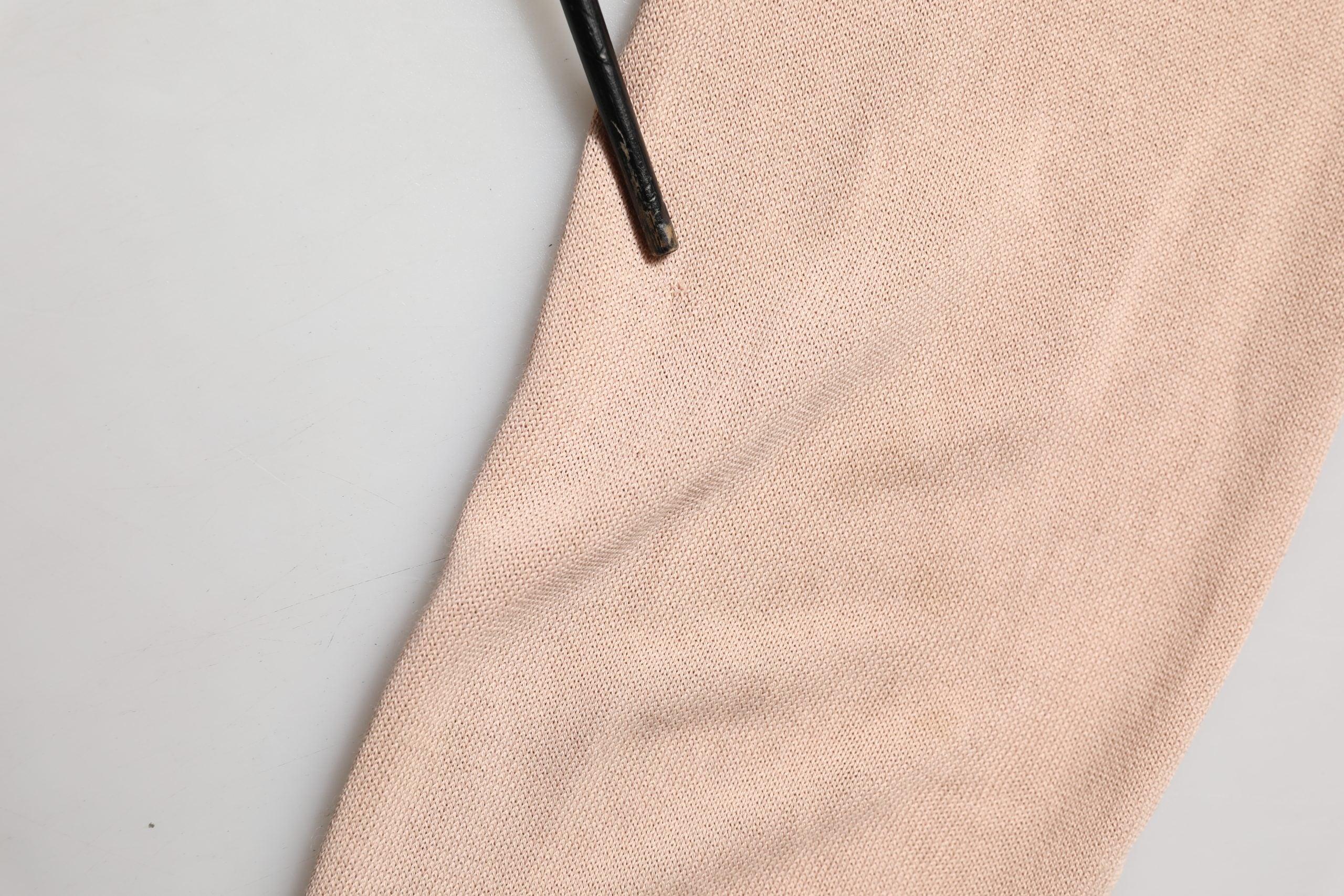 Cardigan beige à col en V à rayures avec nœud à l'avant de la marque Dolce & Gabbana, en maille côtelée.