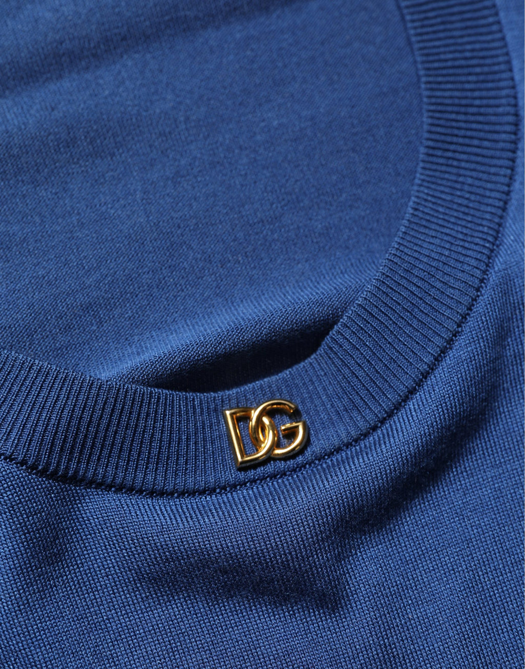 Pull noir en soie Dolce & Gabbana avec logo DG, col ras du cou, élégant et confortable, visible en gros plan.