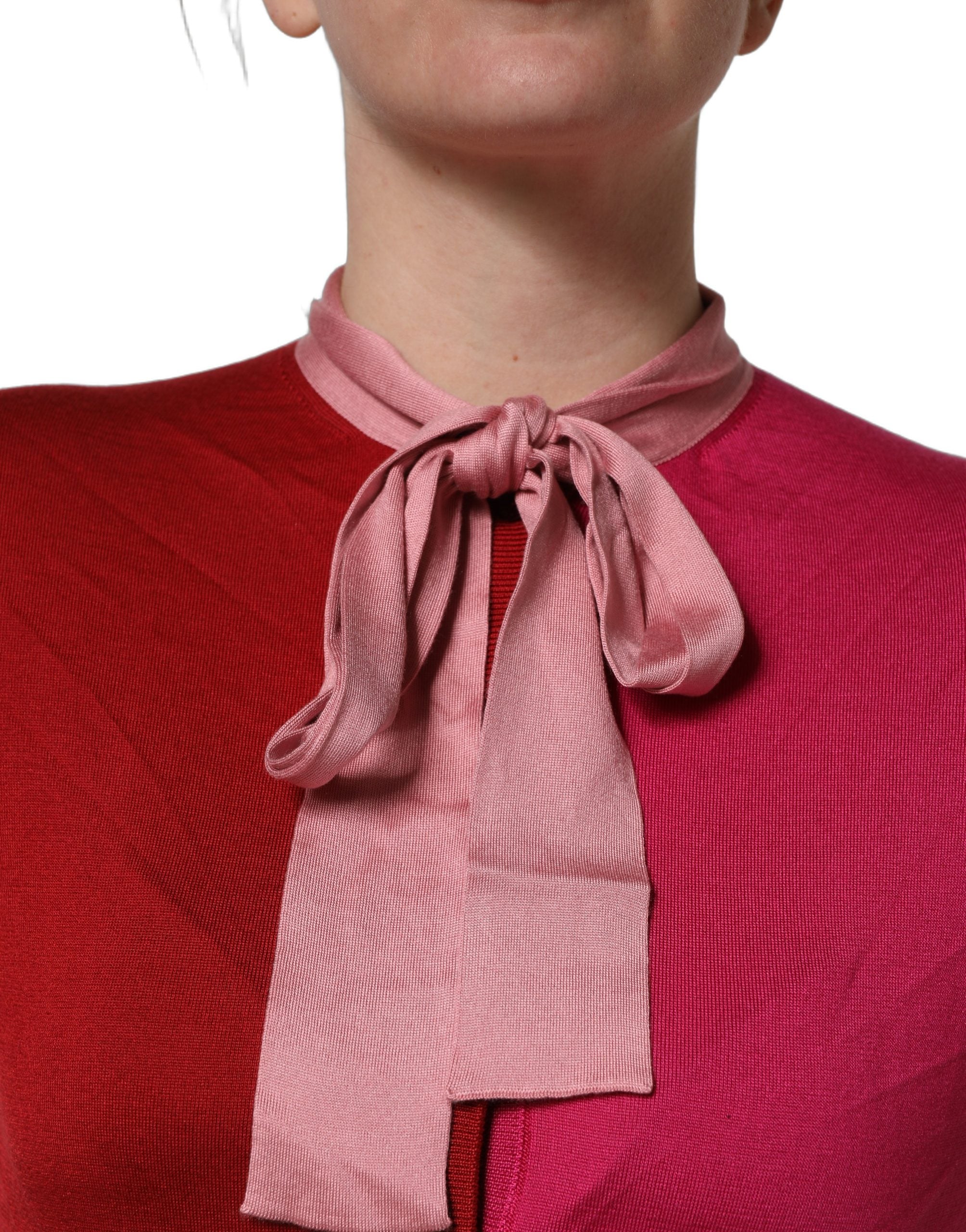 Haut Dolce & Gabbana rose à manches courtes avec col ascot boutonné, style élégant et féminin.