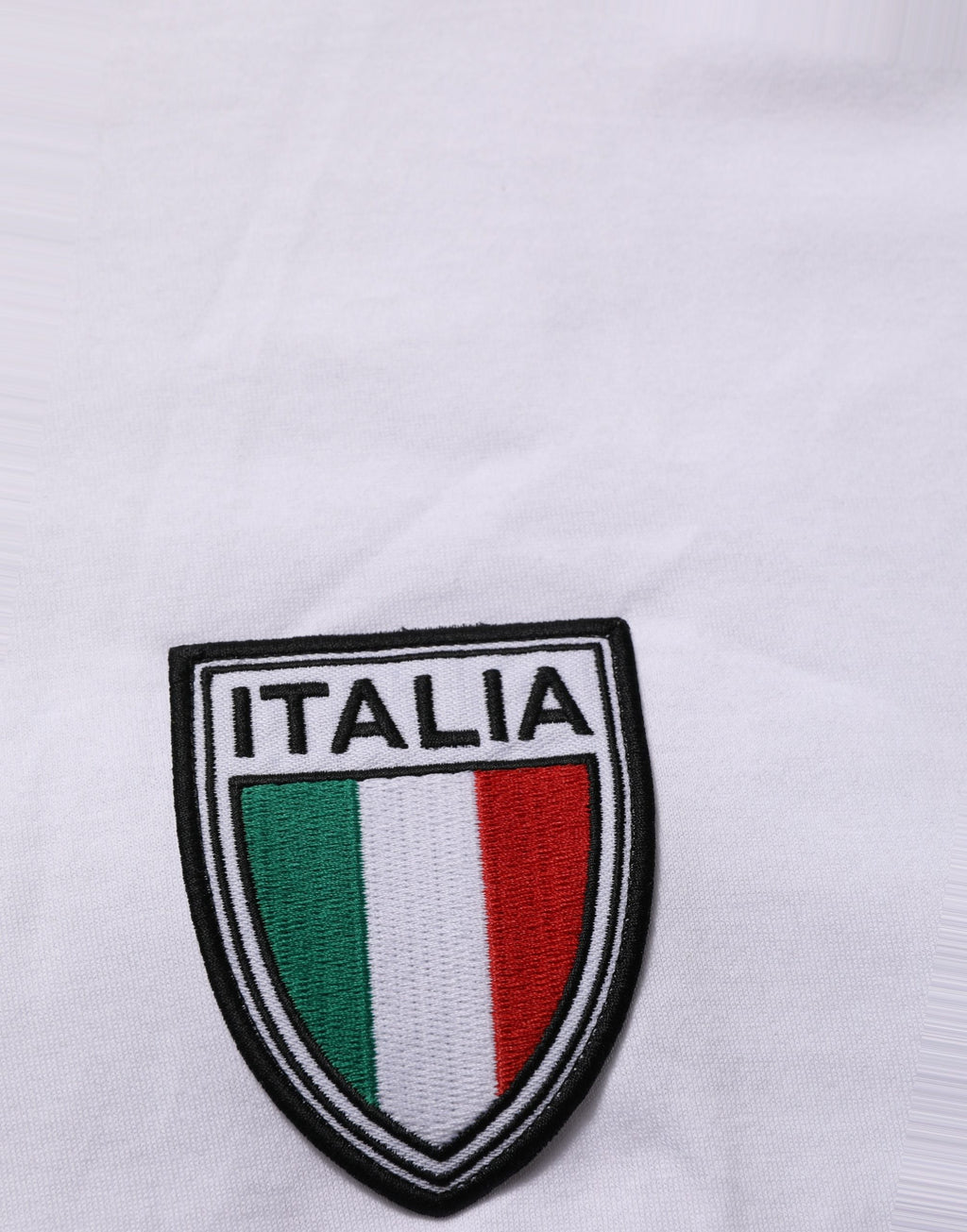 T-shirt rond Dolce & Gabbana blanc avec patch du drapeau italien, col rond et design élégant, visible sur l'image.