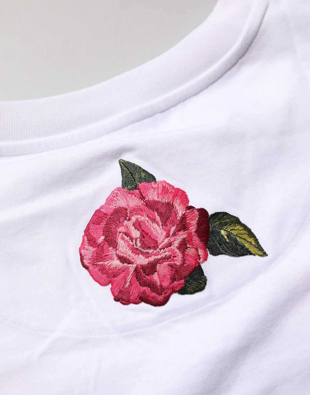 T-shirt crop en coton blanc avec motif floral Dolce & Gabbana, style décontracté et élégant, visible sur l'image.