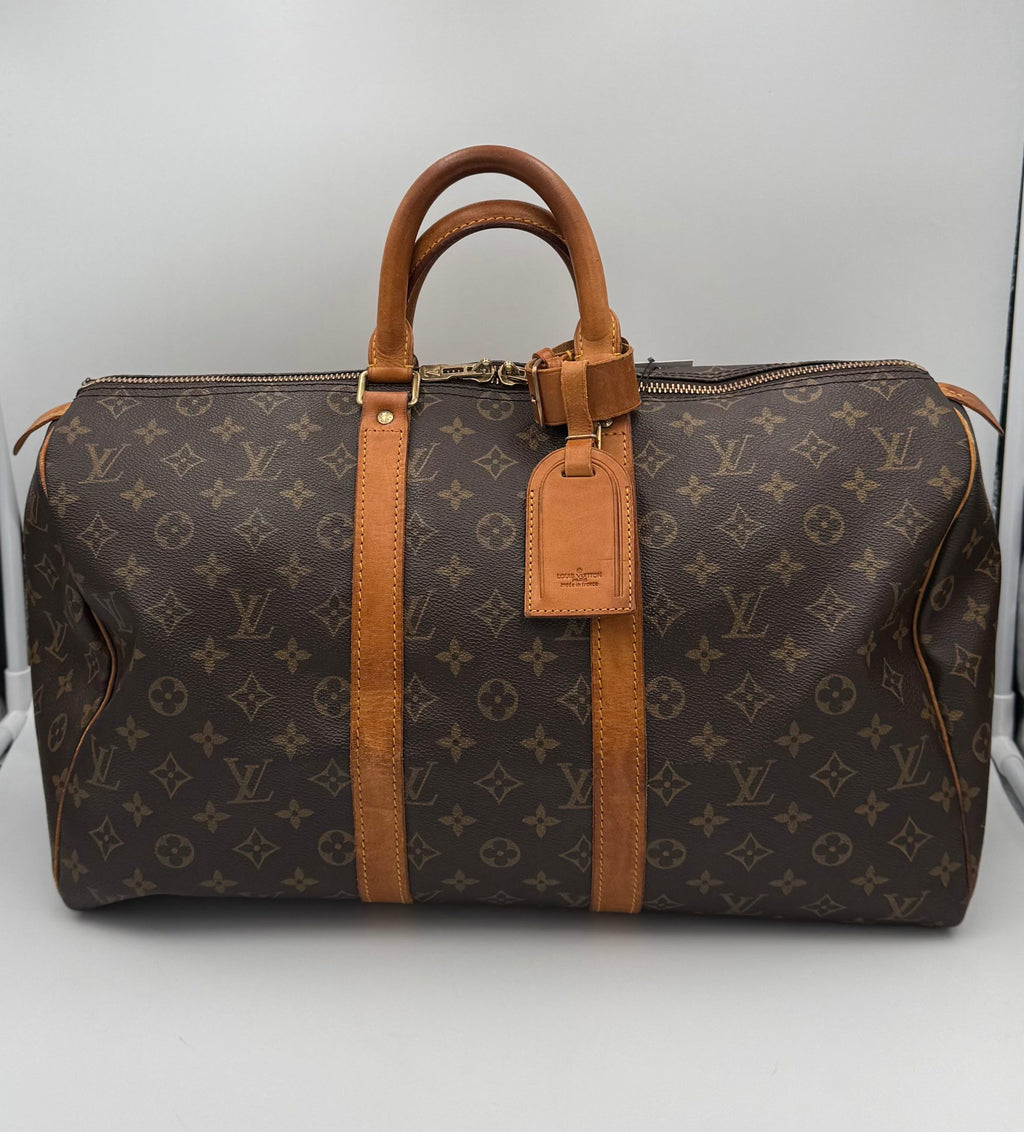 Sac à main Louis Vuitton Keepall 45 en toile Monogram avec poignées en cuir et fermeture zippée visible.