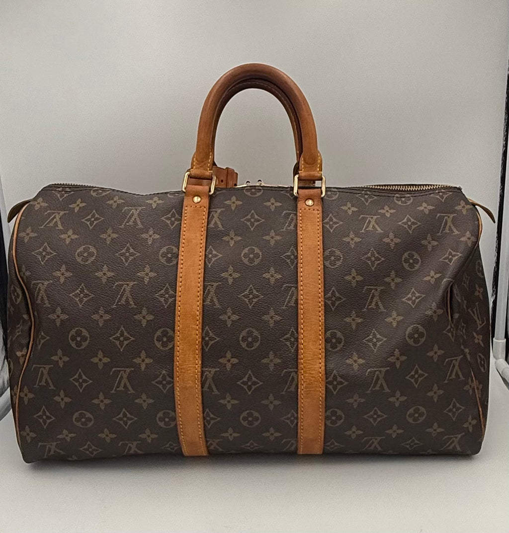 Sac à main Louis Vuitton Keepall 45 en toile monogramme, avec poignées en cuir et fermeture zippée élégante.