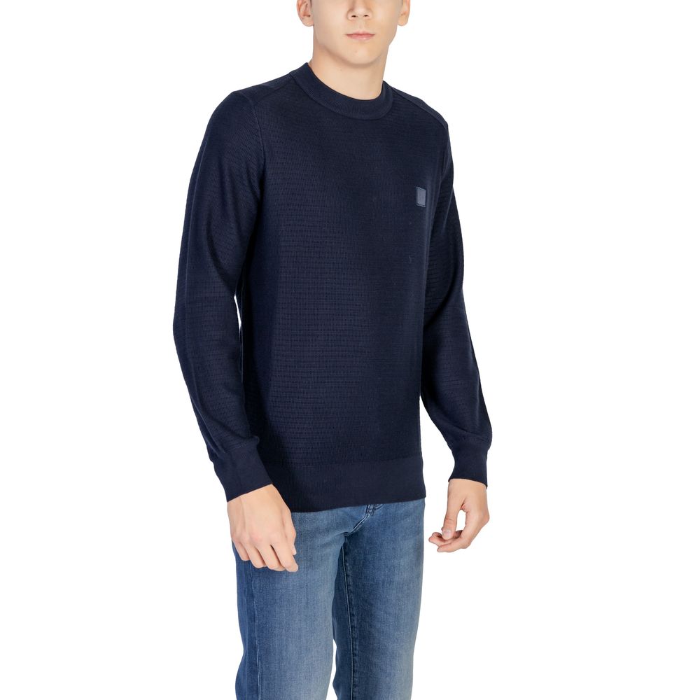 Sweat-shirt bleu en coton de la marque Hugo Boss, avec logo discret, porté dans une tenue décontractée.