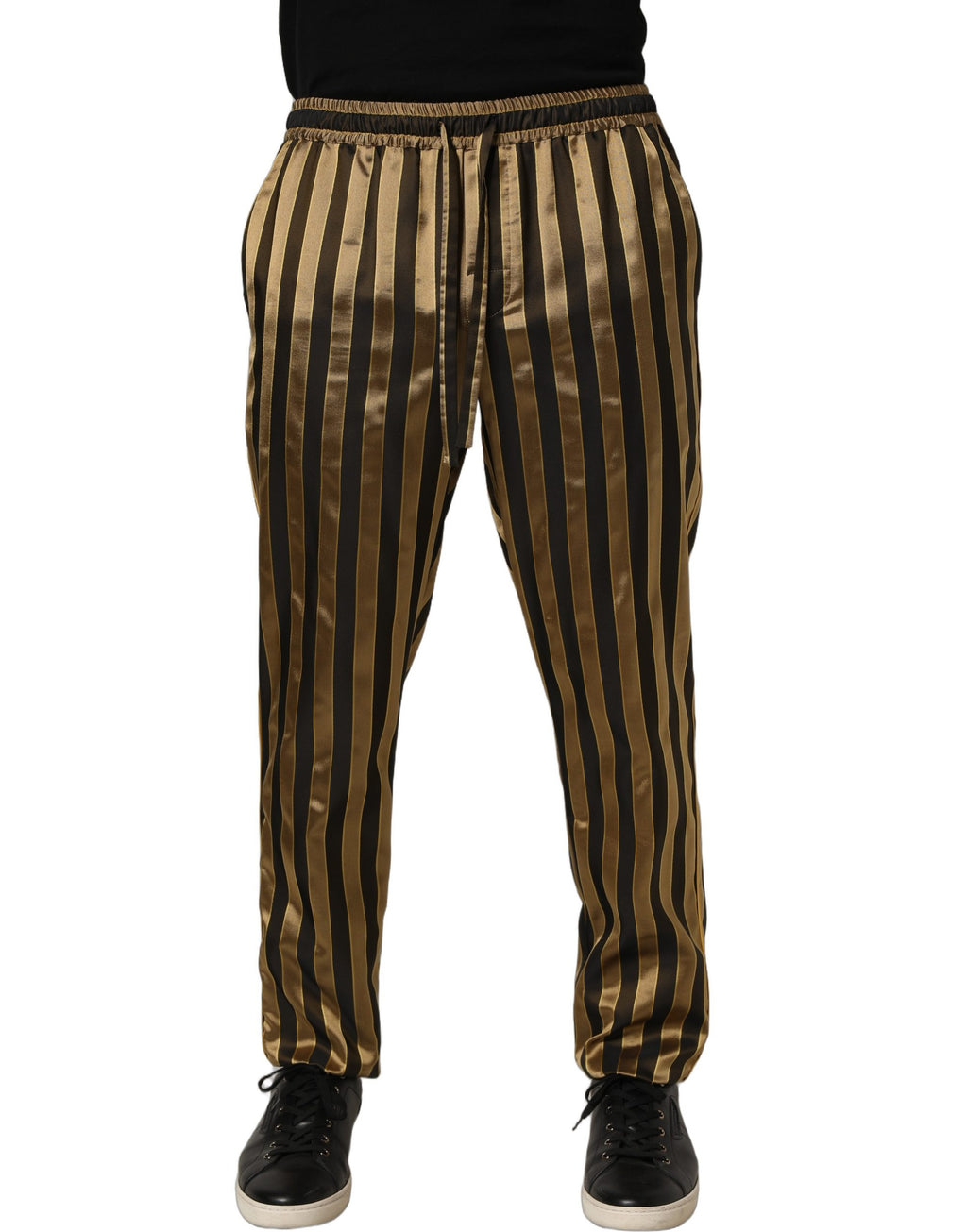 Pantalons pour homme Dolce & Gabbana en satin noir et or à rayures, coupe tapered, visible en détail sur l'image.