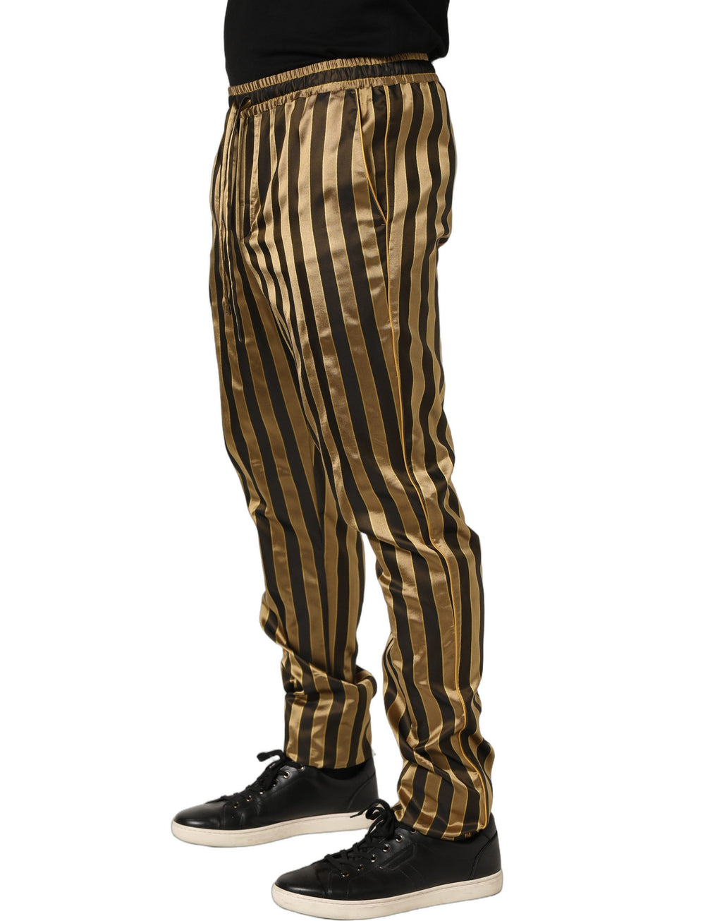 Pantalon homme en satin noir avec rayures dorées et noires, coupe tapered, de la marque Dolce & Gabbana.