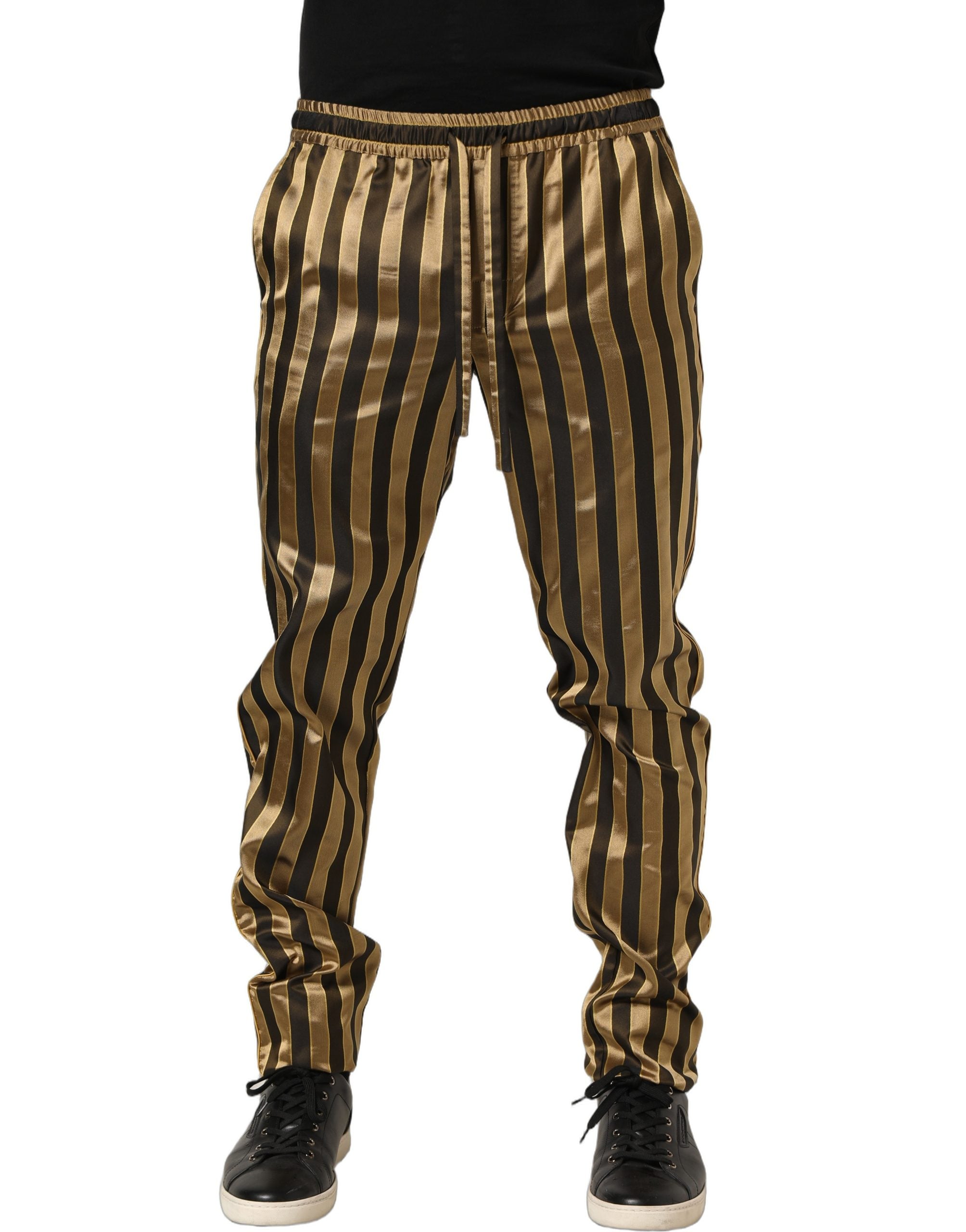 Pantalon homme Dolce & Gabbana en satin noir et or à rayures, coupe tapered, élégance et style sophistiqué.