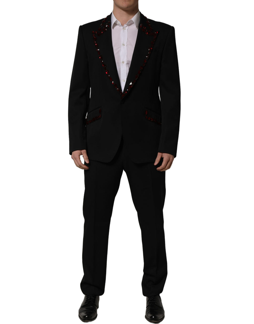 Costume deux pièces noir Dolce & Gabbana avec cristaux scintillants, veste et pantalon élégants, détails luxueux visibles.