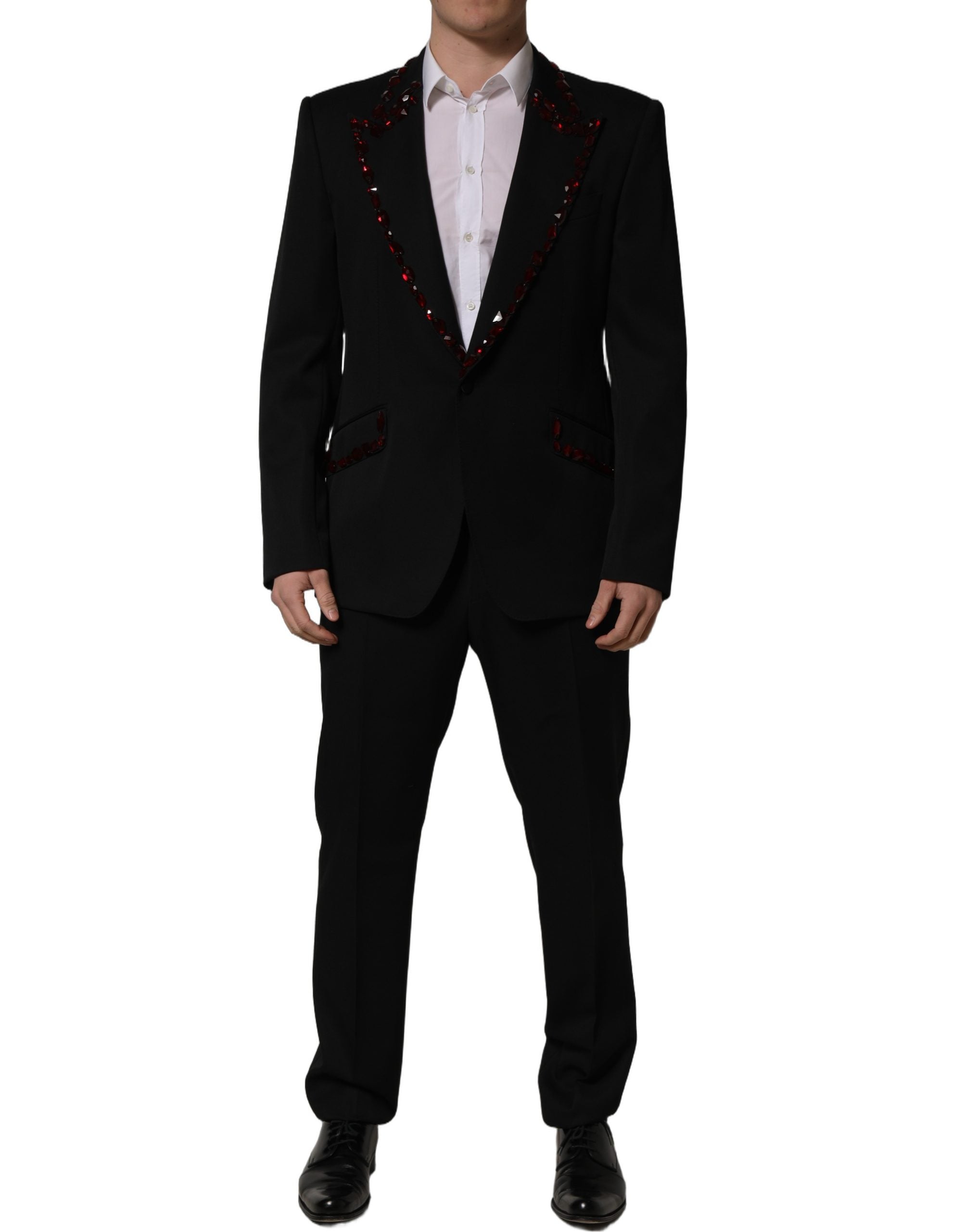 Costume deux pièces noir Dolce & Gabbana avec cristaux scintillants, veste et pantalon élégants, détails luxueux visibles.