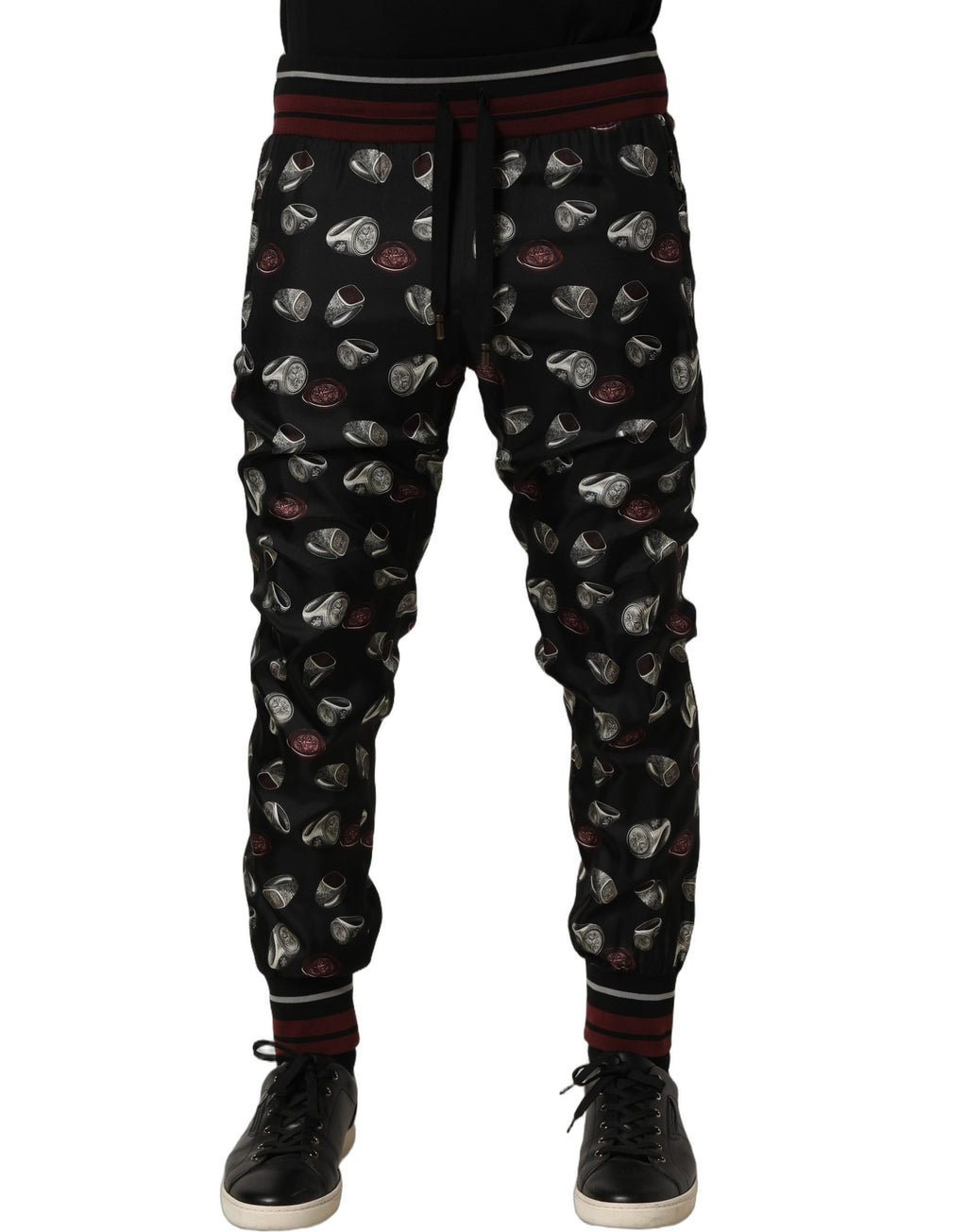 Pantalons de jogging en soie noire Dolce & Gabbana avec motif anneau, style décontracté et élégant.