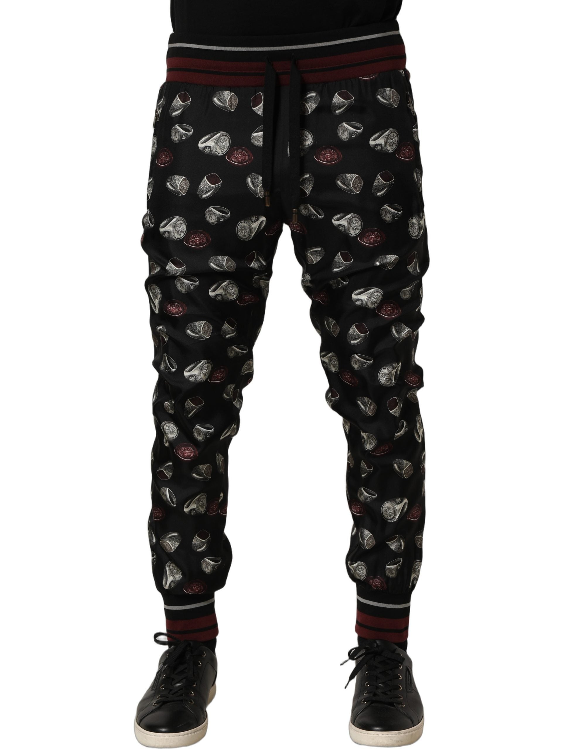 Pantalons de jogging en soie noire Dolce & Gabbana avec motif anneau, style décontracté et élégant.