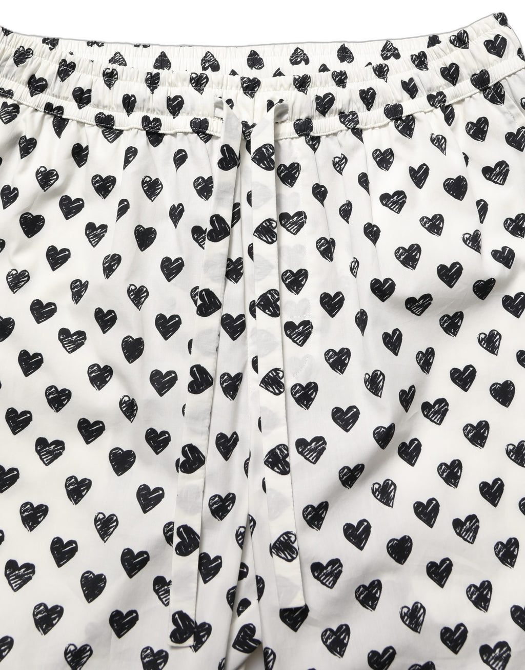Pantalon homme blanc Dolce & Gabbana avec motif graphique de cœur, style élégant et moderne.