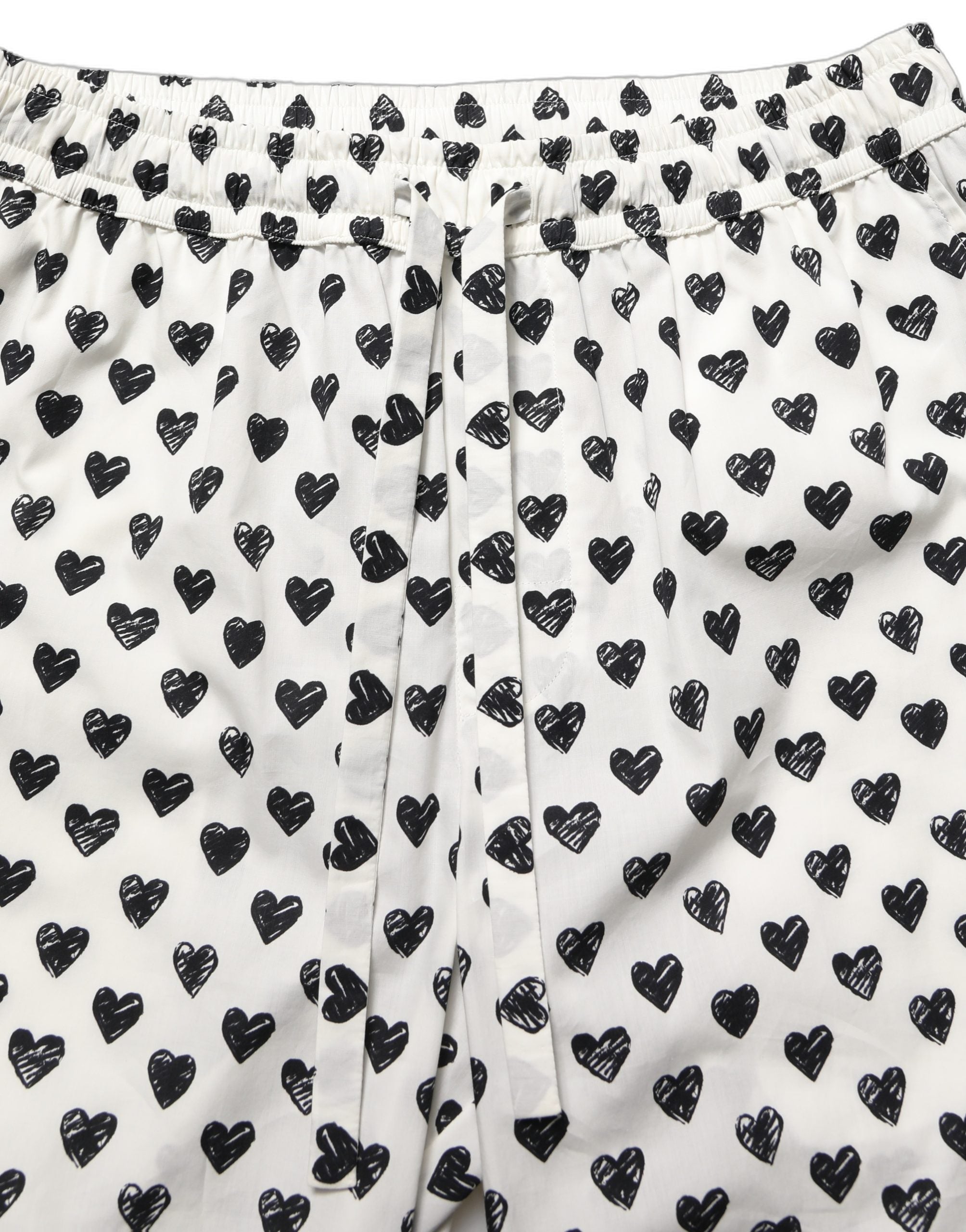 Pantalon homme blanc Dolce & Gabbana avec motif graphique de cœur, style élégant et moderne.