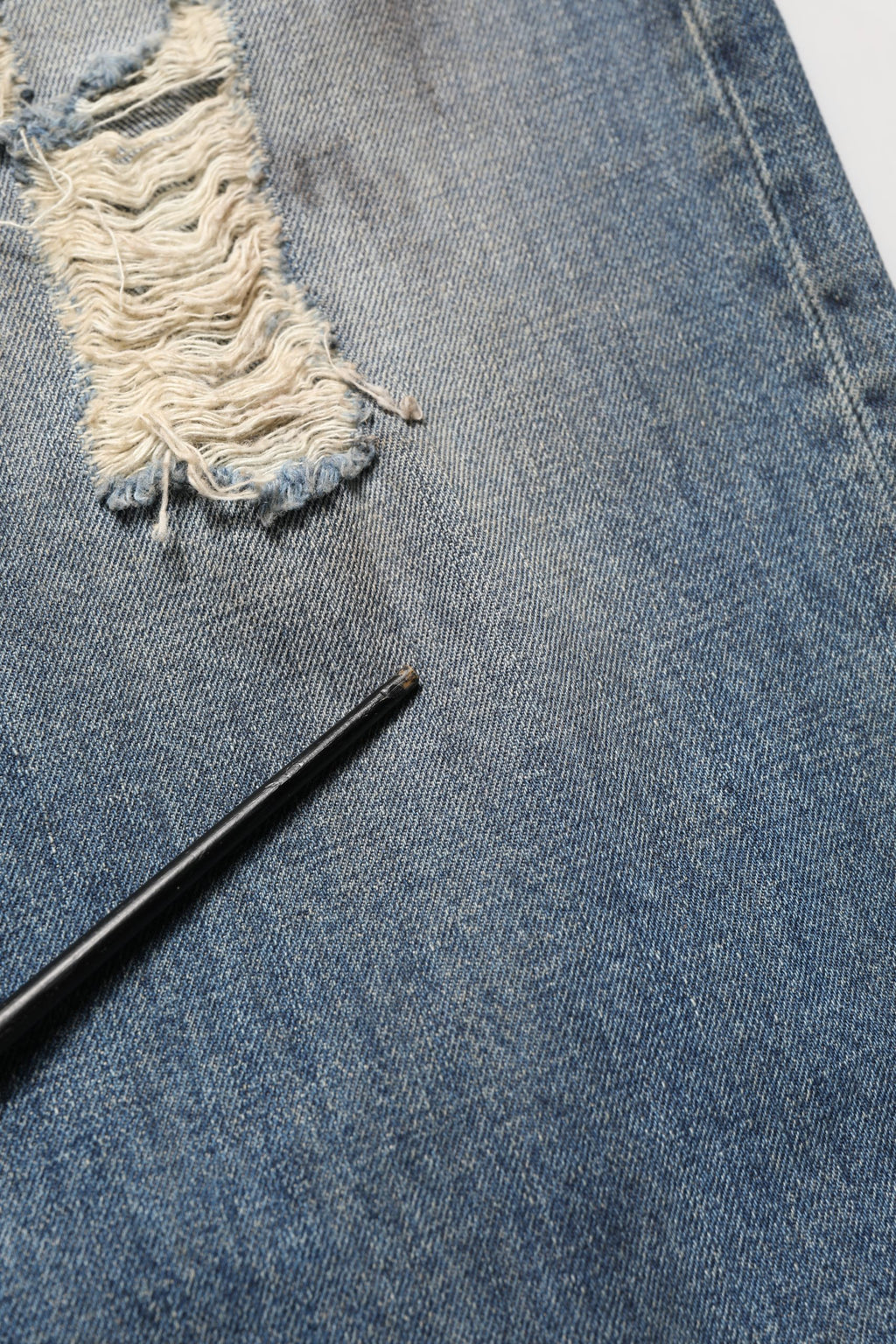 Jeans en denim bleu Dolce & Gabbana, coupe droite et déchirée, en coton, visible avec détails usés et style décontracté.