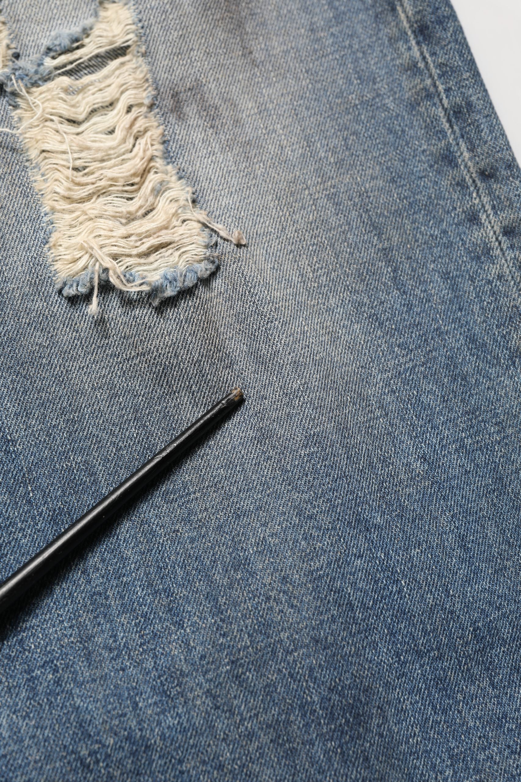 Jeans en denim bleu Dolce & Gabbana, coupe droite et déchirée, en coton, visible avec détails usés et style décontracté.
