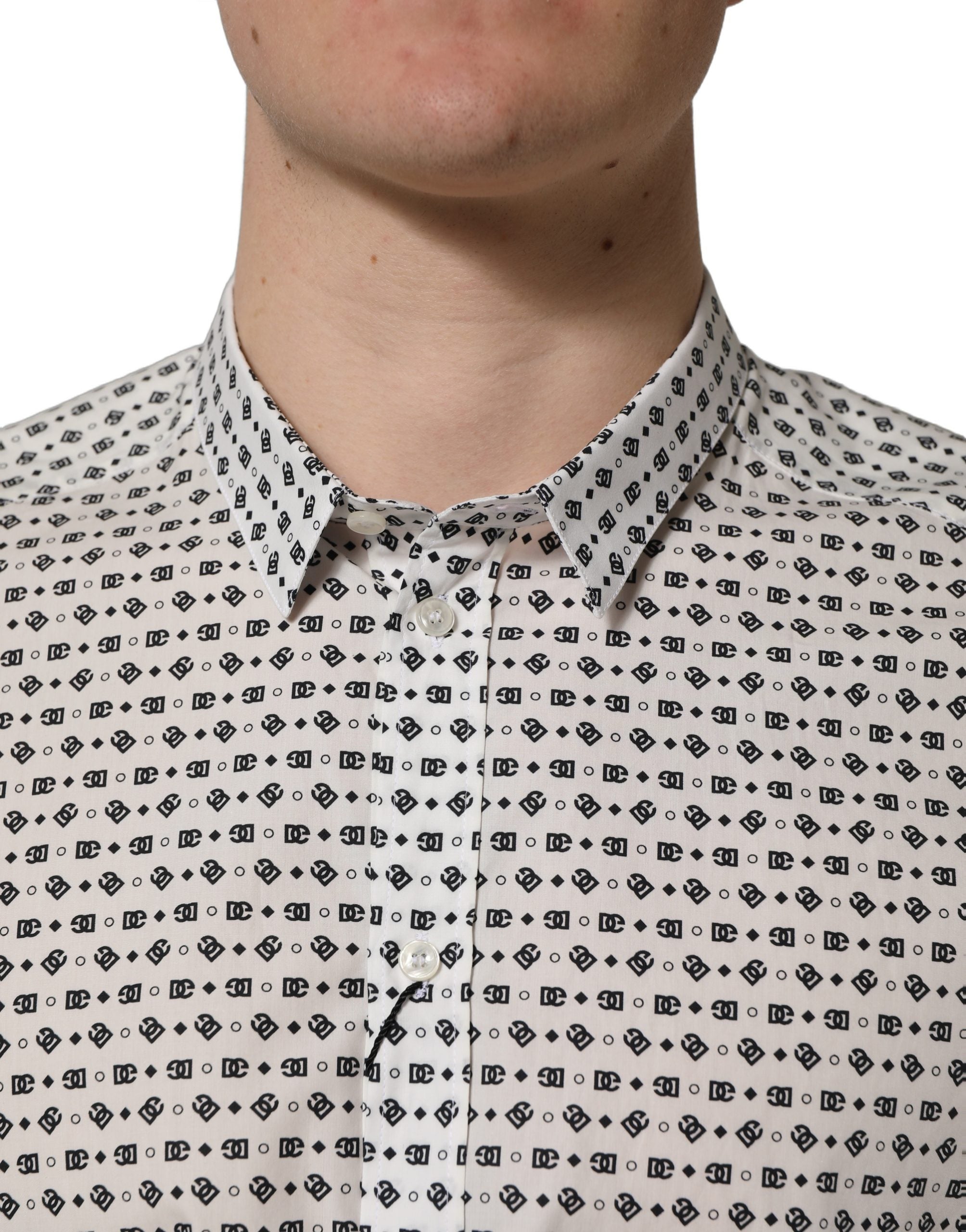 Chemise longue blanche Dolce & Gabbana avec logo doré, manches longues et design élégant visible sur l'image.