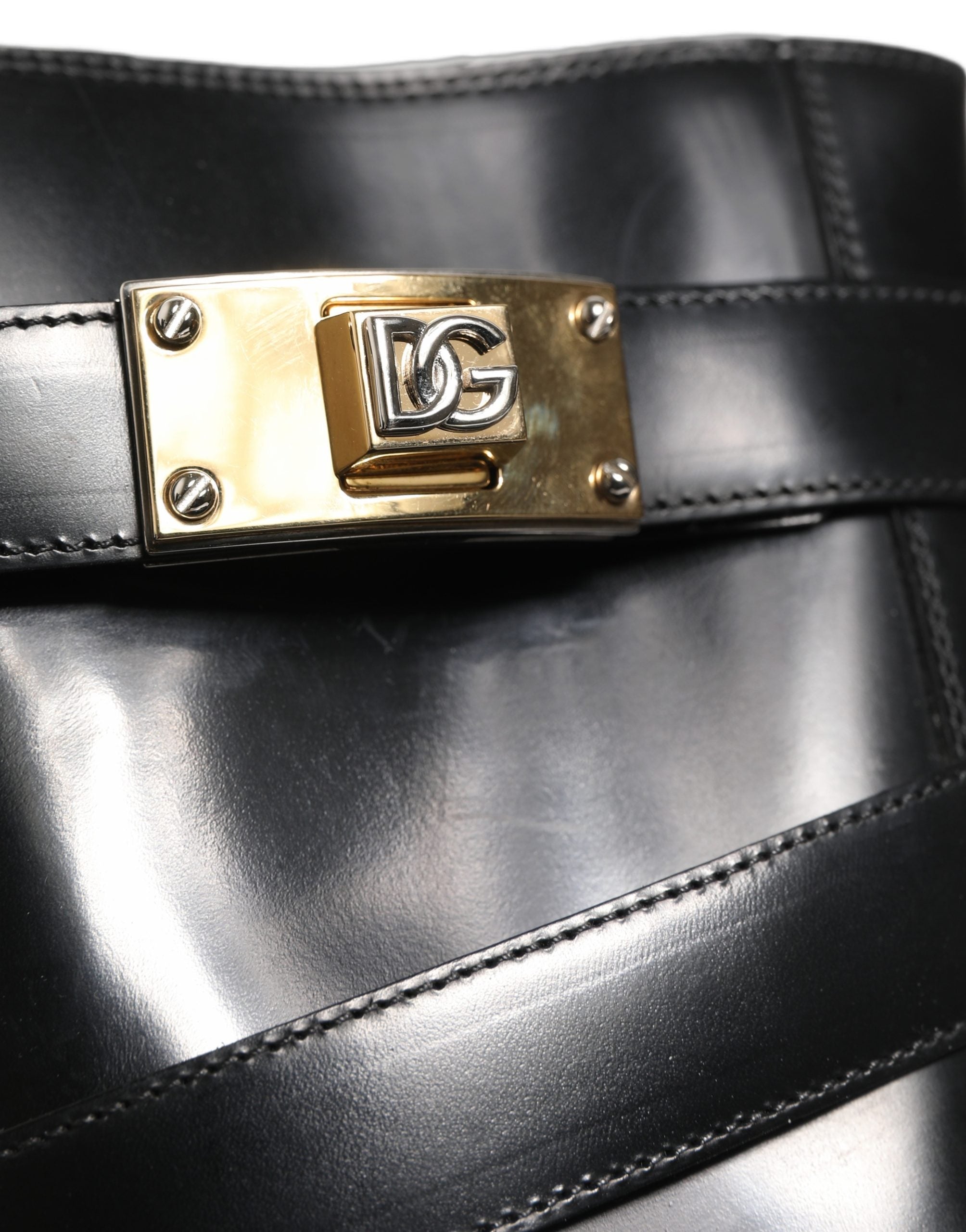 Bottes mi-mollet en cuir noir Dolce & Gabbana avec plaque DG, style élégant et sophistiqué visible sur l'image.
