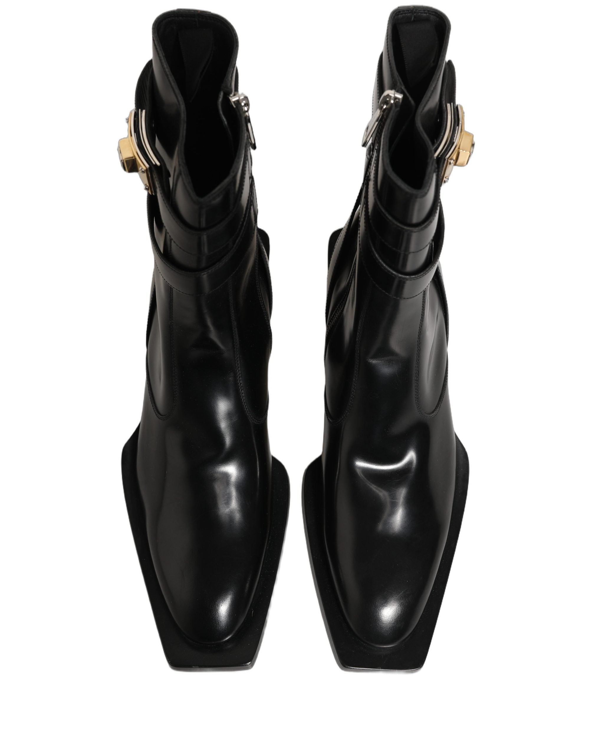 Bottes en cuir noir Dolce & Gabbana avec plaque DG, mi-mollet, style élégant et moderne, visibles de face sur fond neutre.