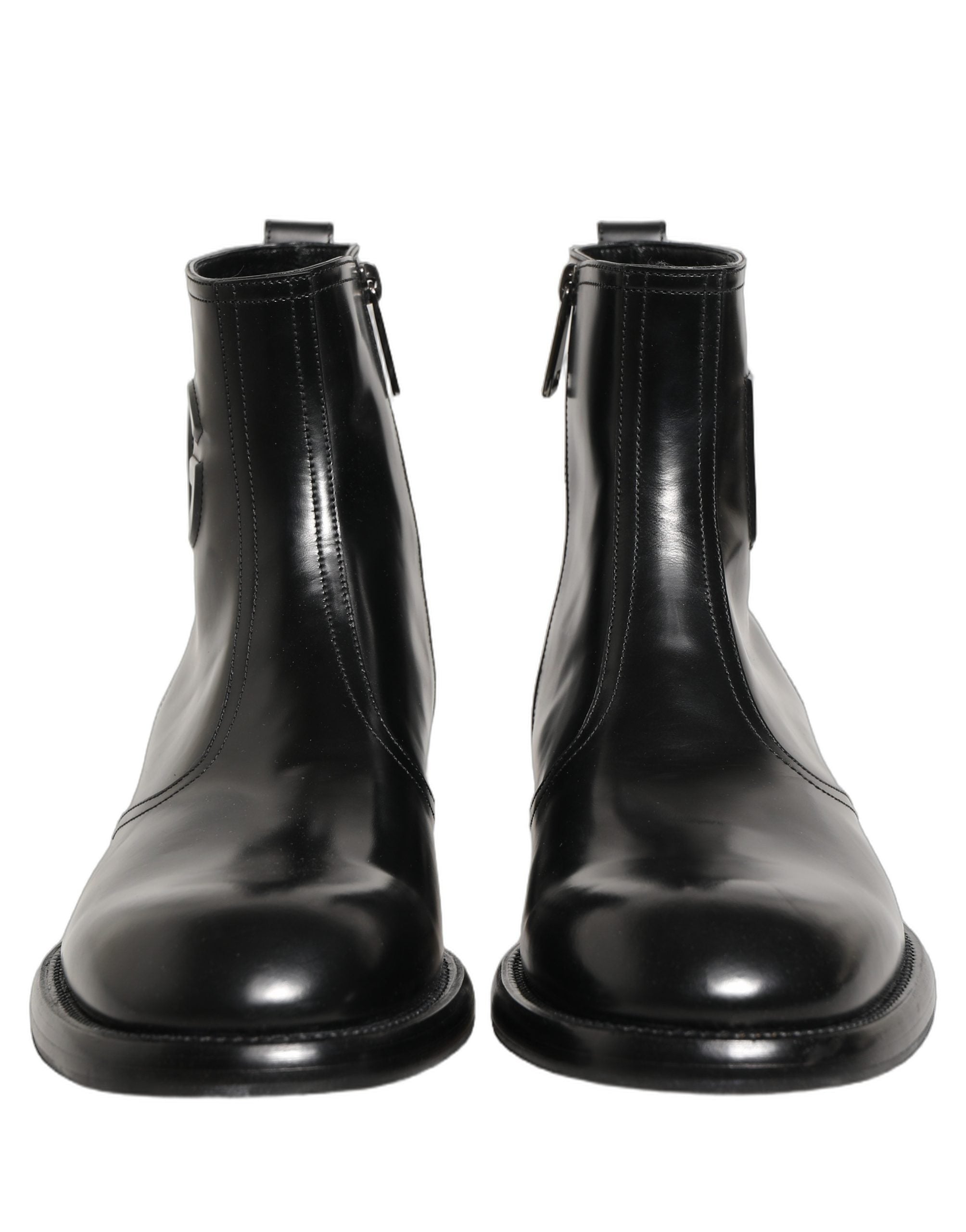 Bottes ankle en cuir noir Dolce & Gabbana avec logo embossed, style élégant et moderne, visibles sur l’image.